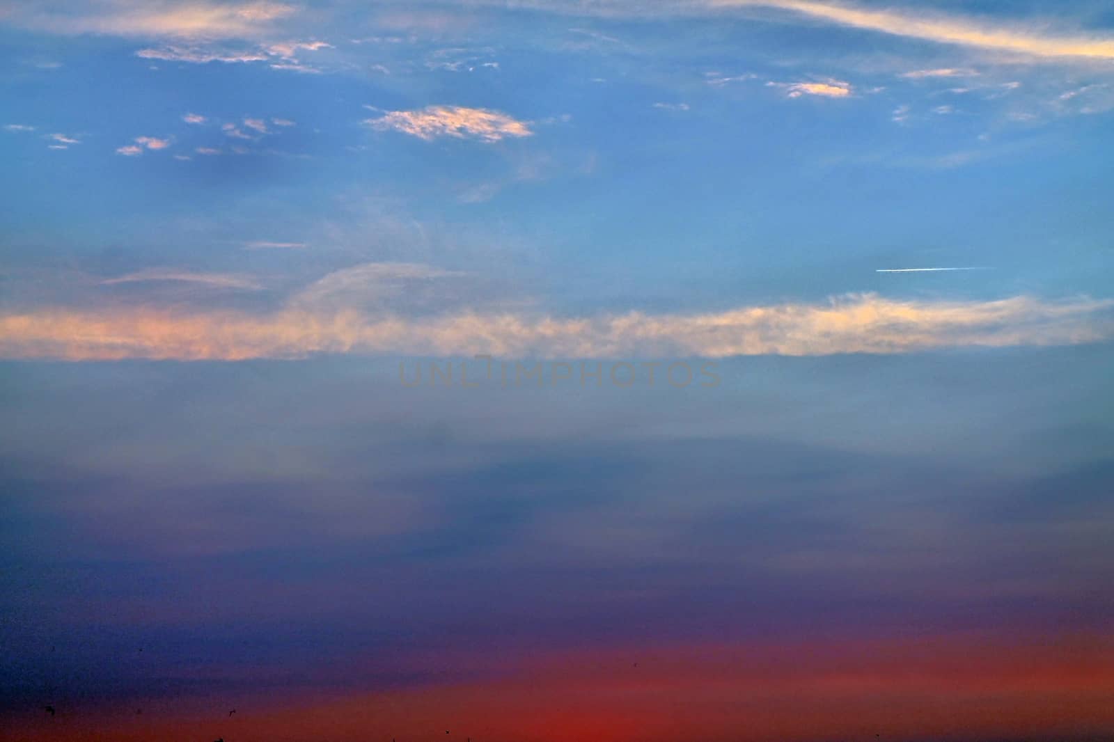 Beautiful panorama of orange and yellow clouds at sunrise and sunset in a blue sky