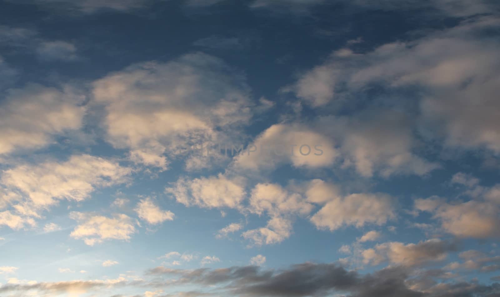 Beautiful panorama of orange and yellow clouds at sunrise and sunset in a blue sky