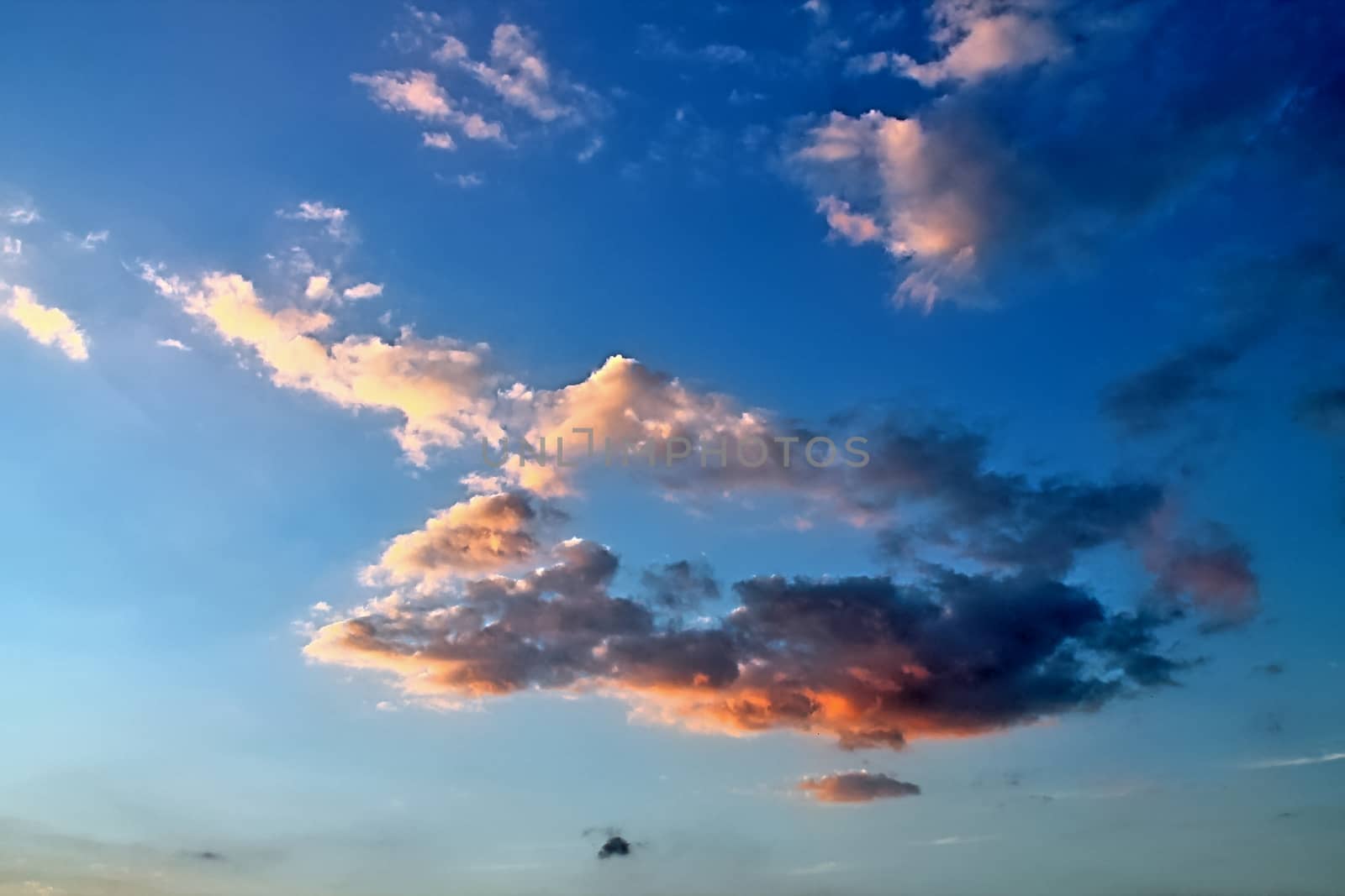 Beautiful panorama of orange and yellow clouds at sunrise and sunset in a blue sky