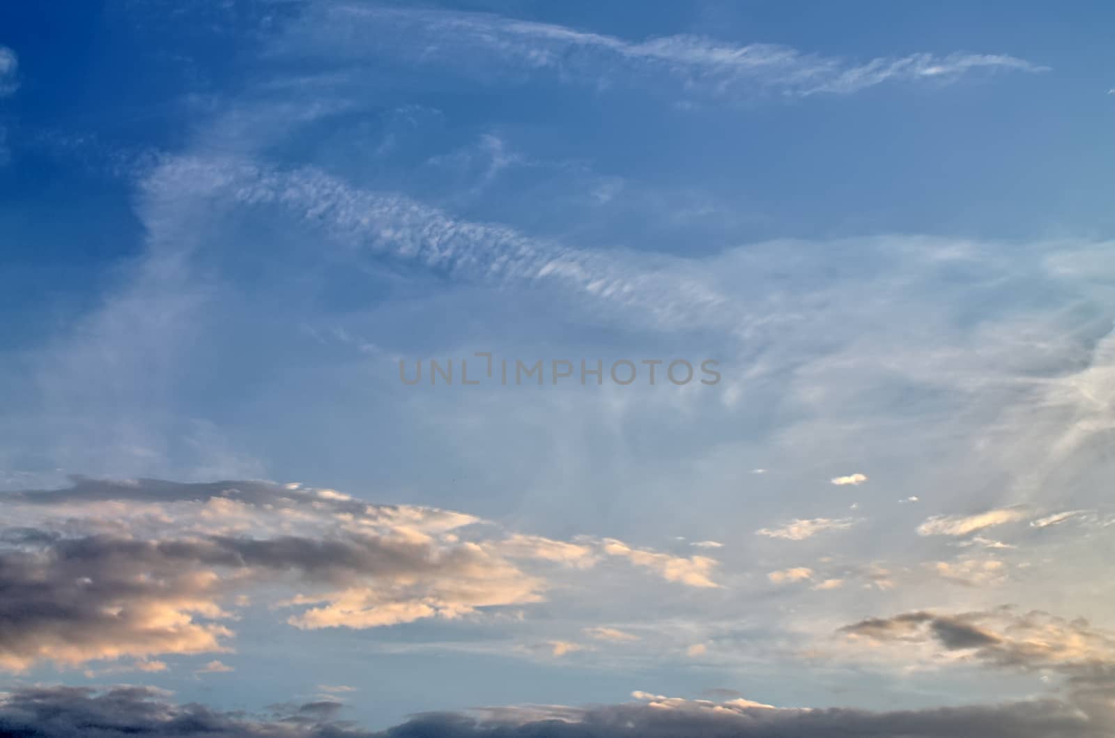 Beautiful panorama of orange and yellow clouds at sunrise and sunset in a blue sky