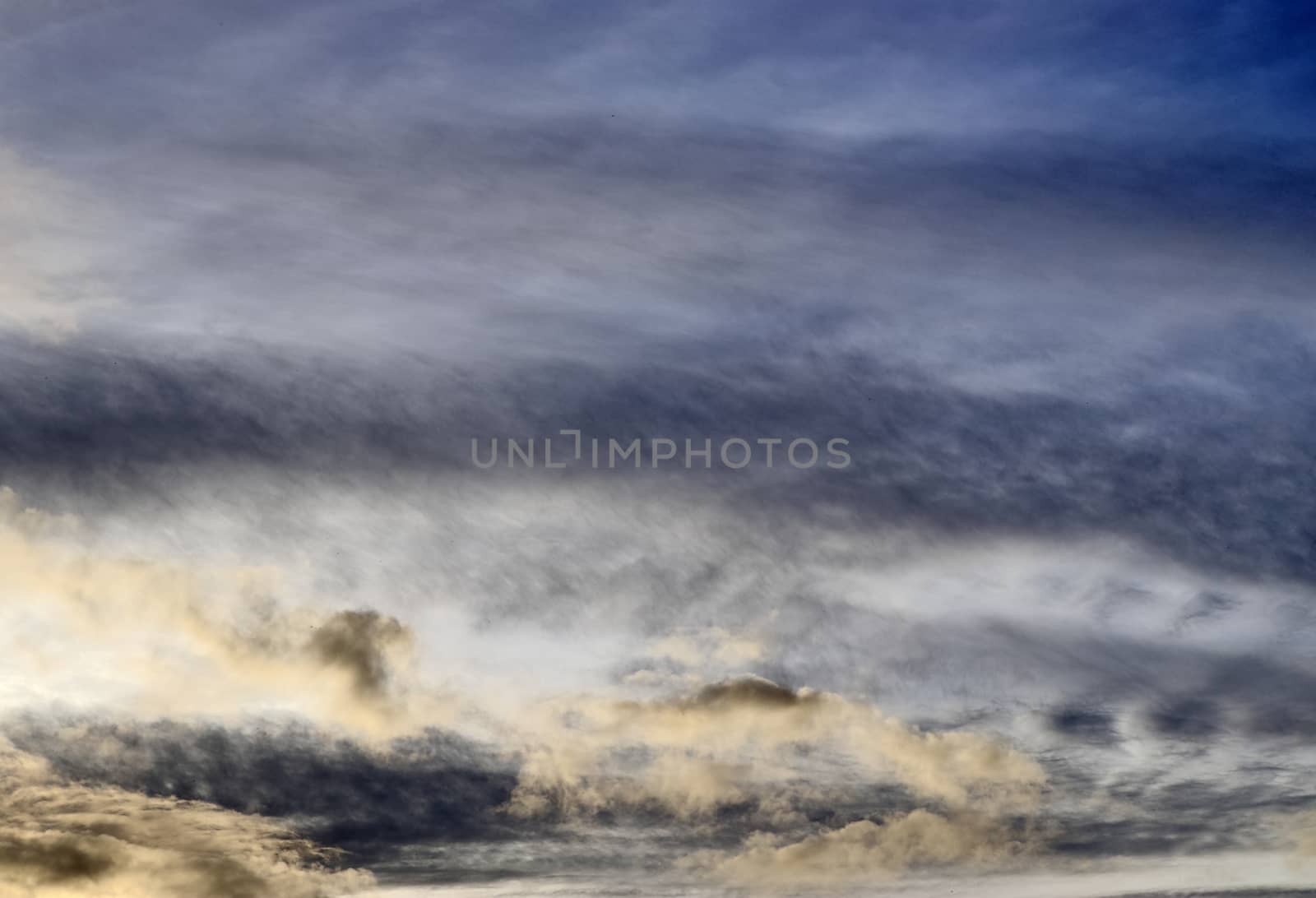 Beautiful panorama of orange and yellow clouds at sunrise and sunset in a blue sky