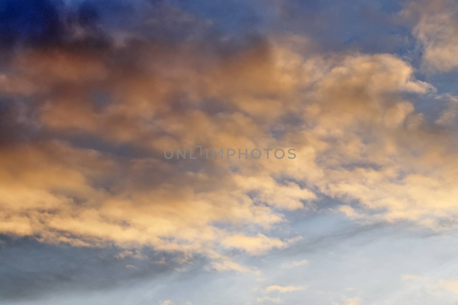 Beautiful panorama of orange and yellow clouds at sunrise and sunset in a blue sky