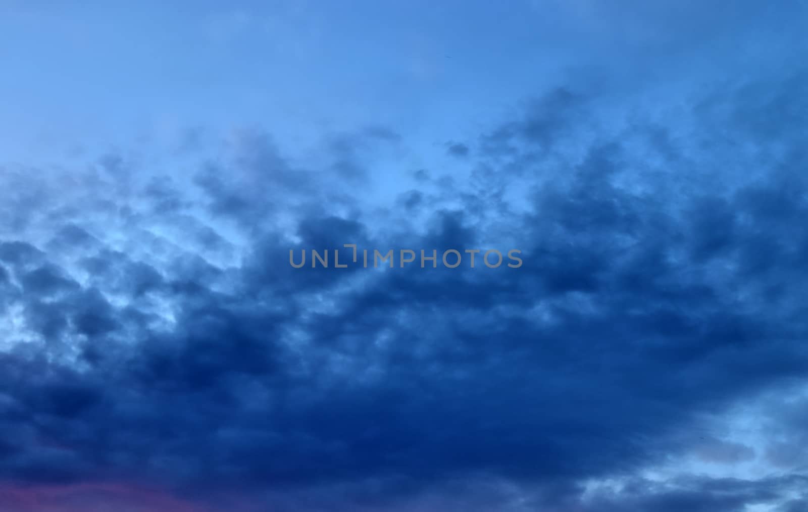 Beautiful panorama of orange and yellow clouds at sunrise and sunset in a blue sky