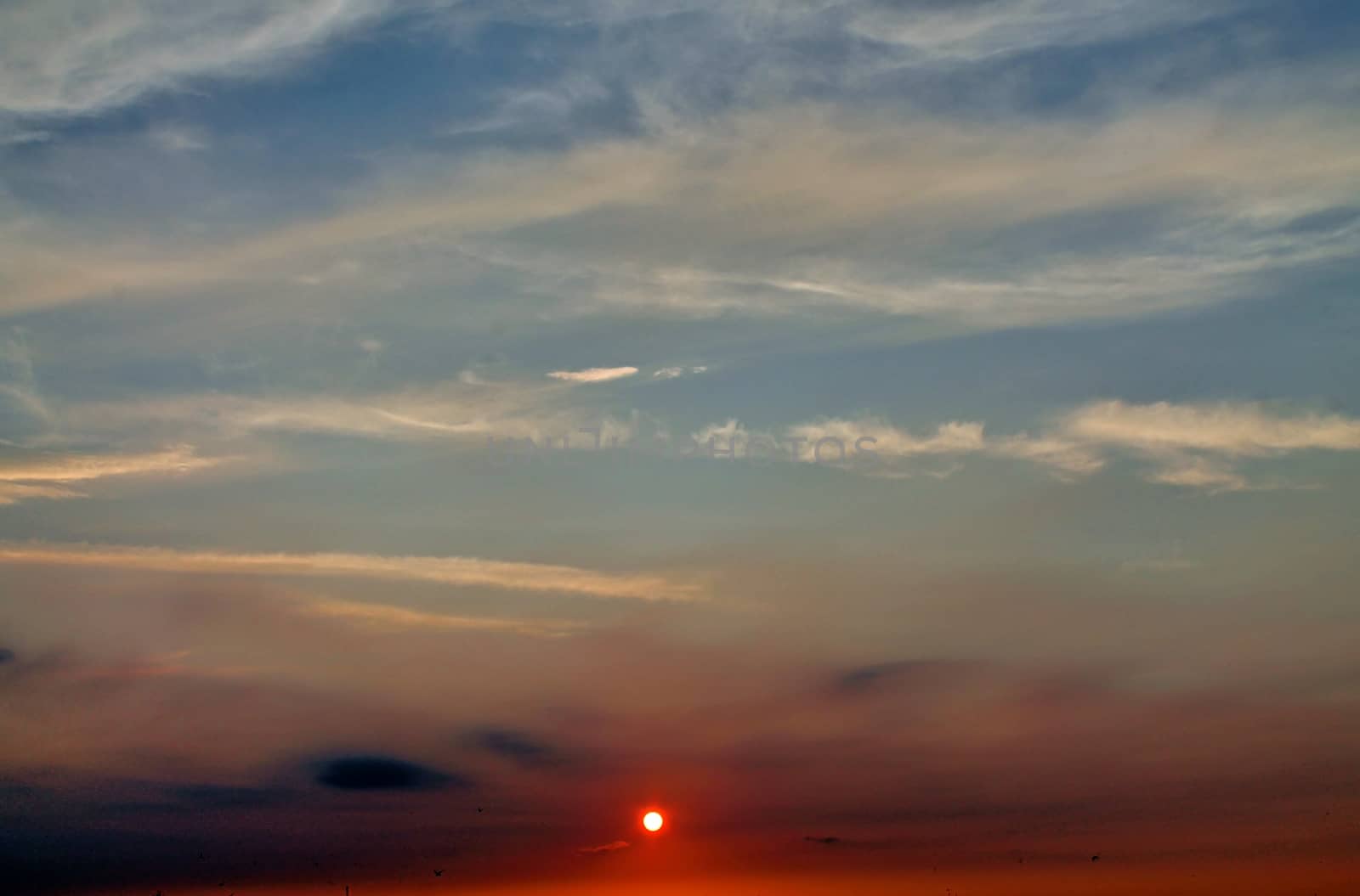 Beautiful panorama of orange and yellow clouds at sunrise and sunset in a blue sky