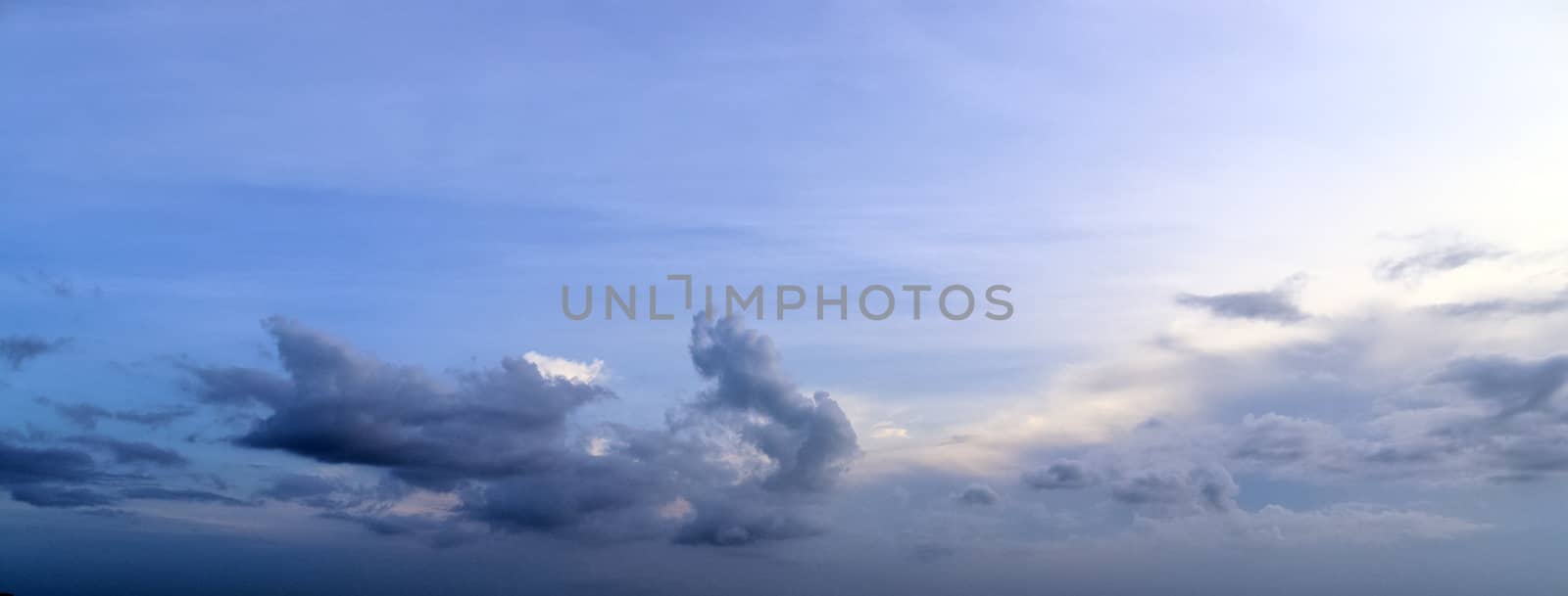 Beautiful panorama of orange and yellow clouds at sunrise and sunset in a blue sky