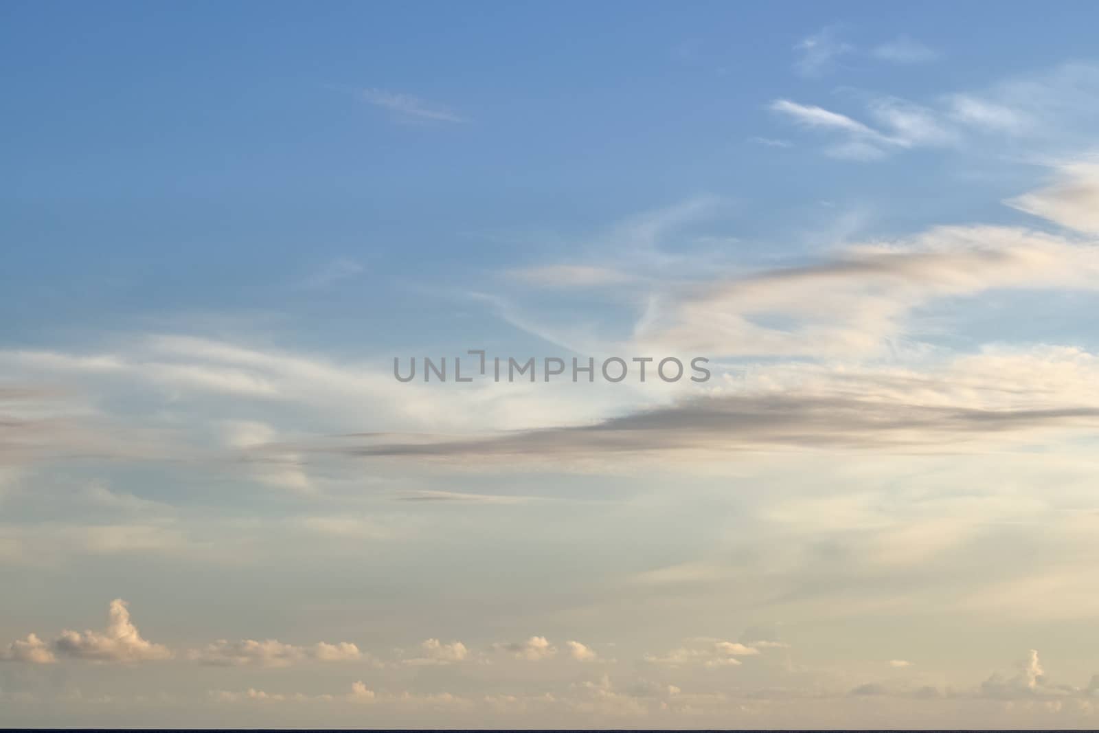 Beautiful panorama of orange and yellow clouds at sunrise and sunset in a blue sky