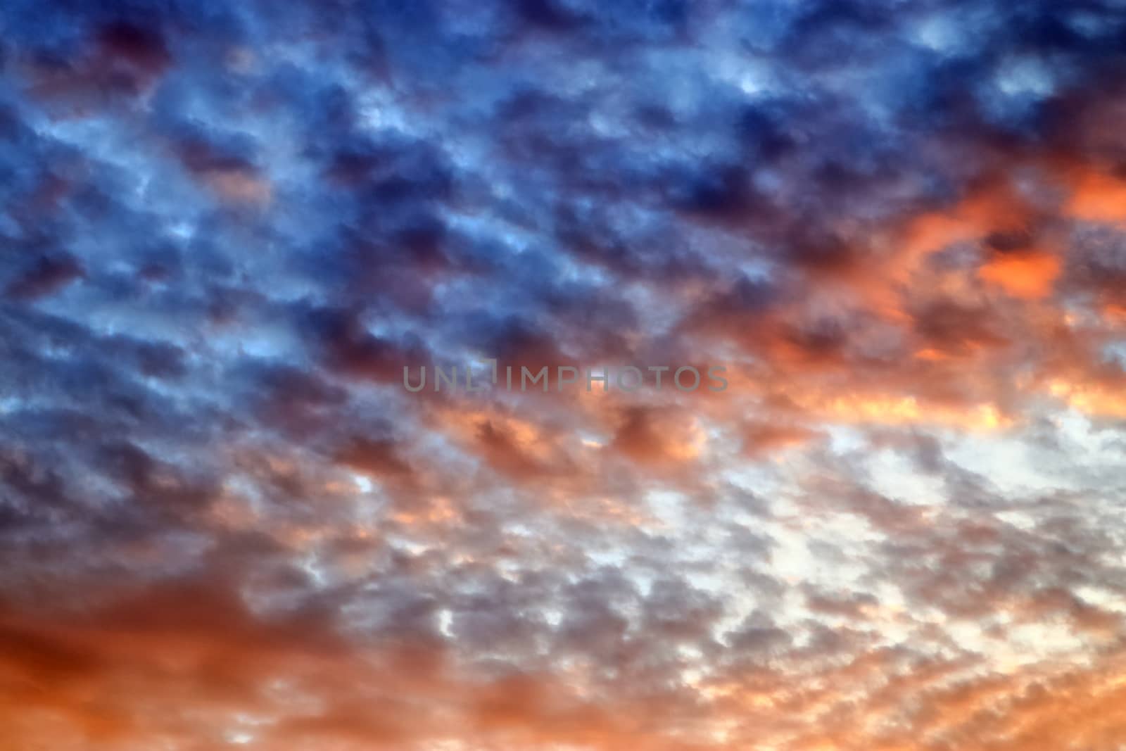 Beautiful panorama of orange and yellow clouds at sunrise and sunset in a blue sky