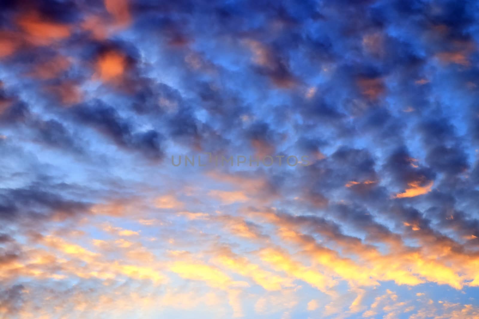 Beautiful panorama of orange and yellow clouds at sunrise and sunset in a blue sky