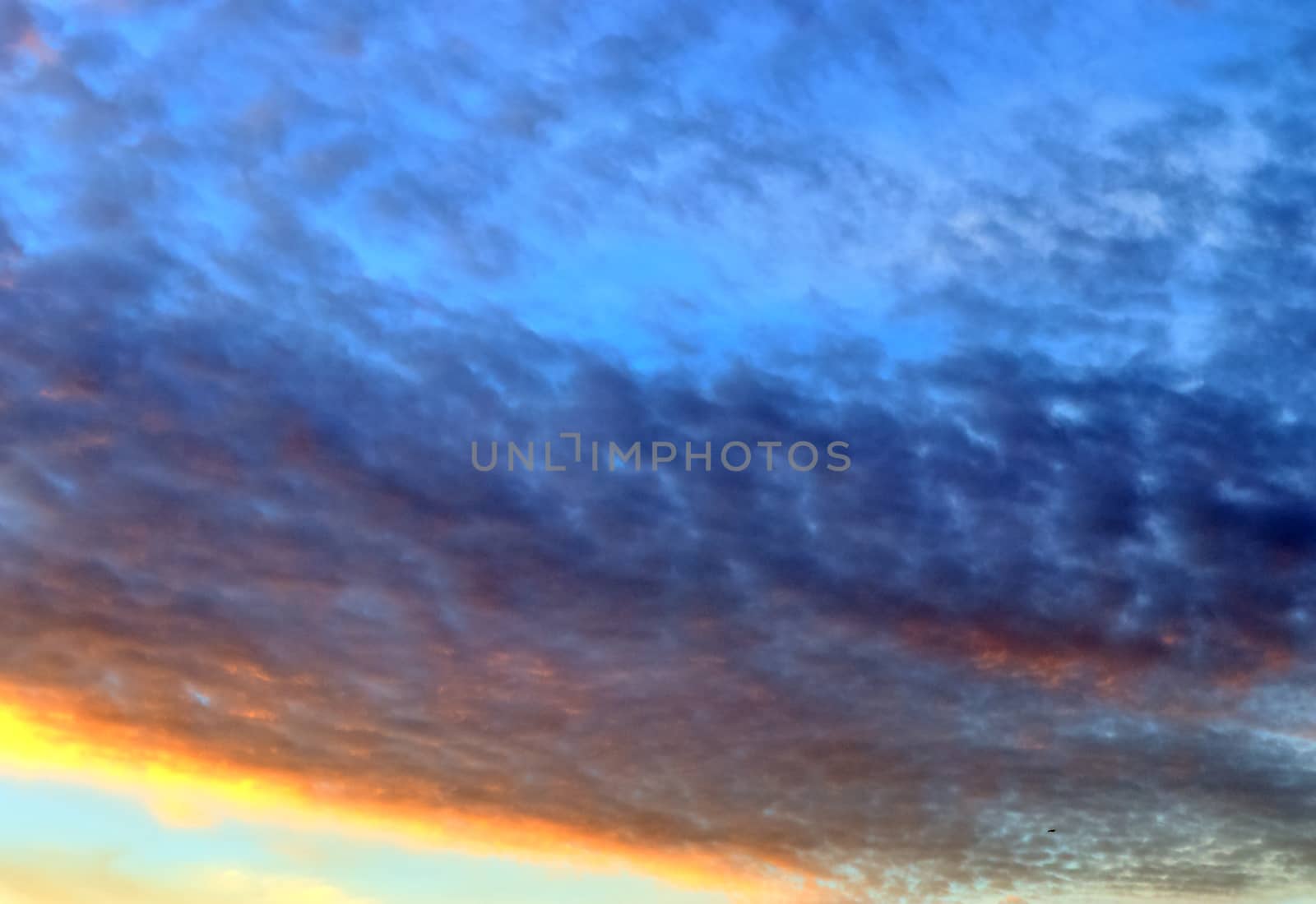 Beautiful panorama of orange and yellow clouds at sunrise and sunset in a blue sky