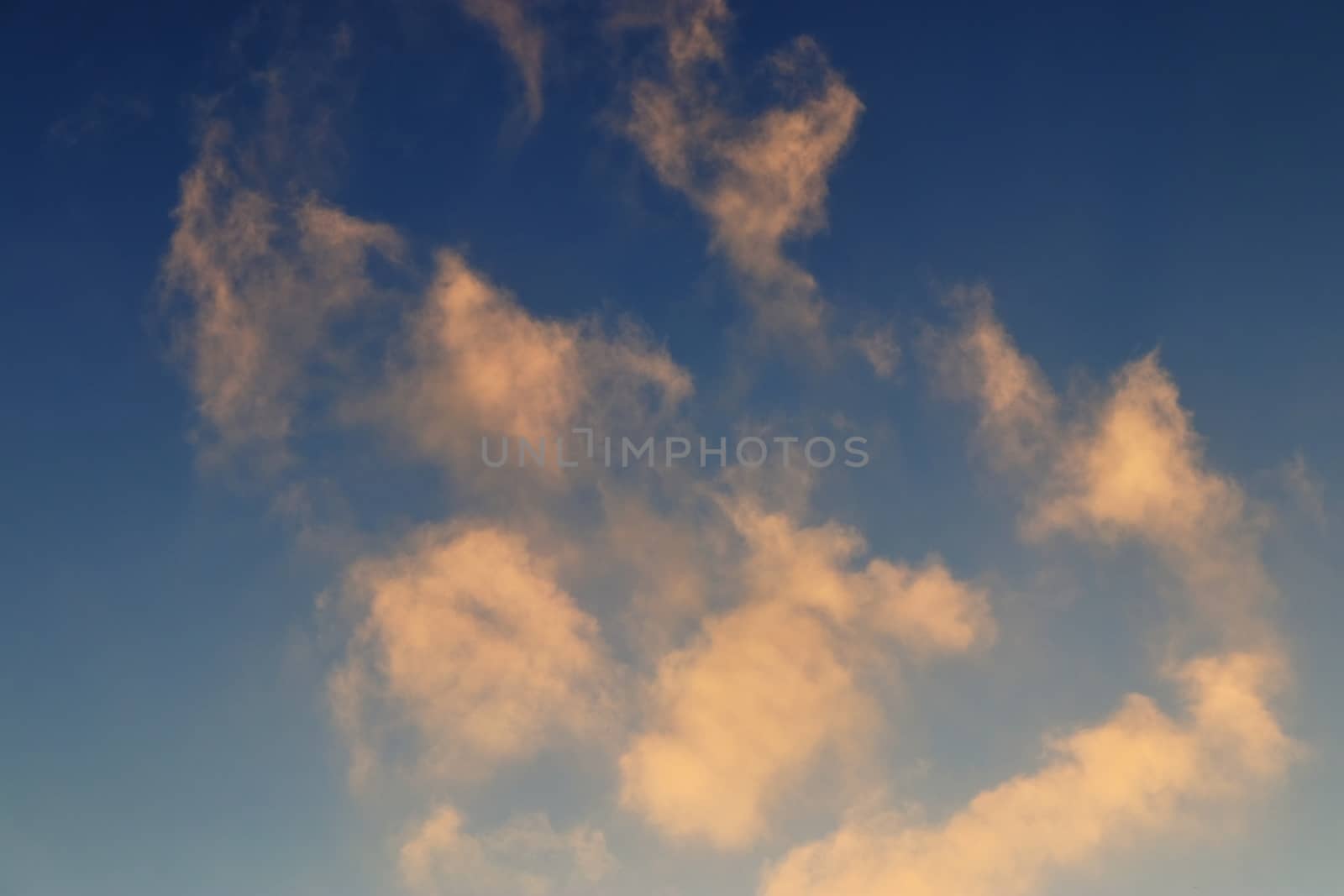 Beautiful panorama of orange and yellow clouds at sunrise and sunset in a blue sky