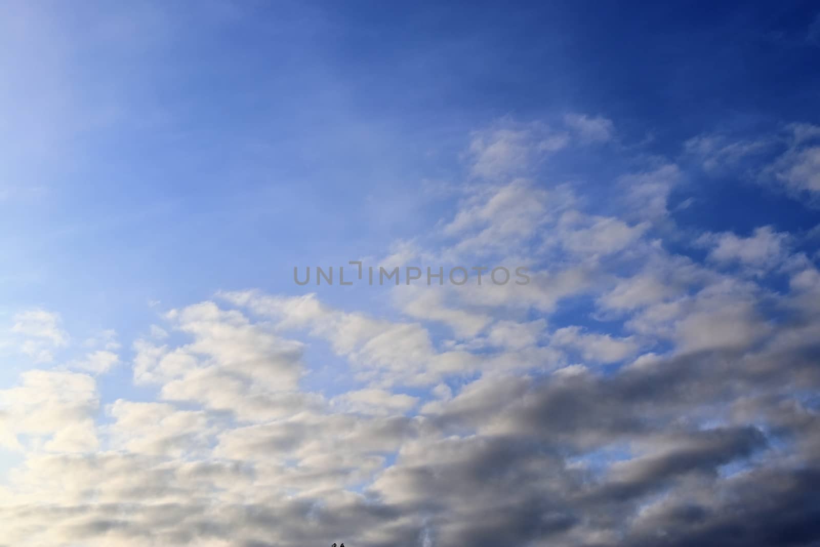 Beautiful panorama of orange and yellow clouds at sunrise and sunset in a blue sky