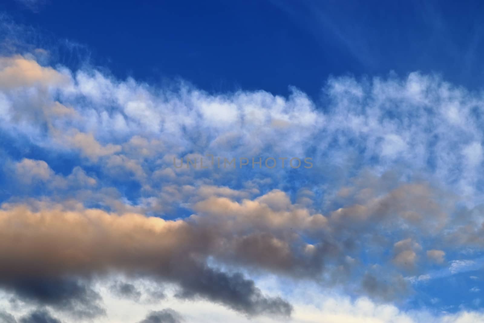 Beautiful panorama of orange and yellow clouds at sunrise and sunset in a blue sky