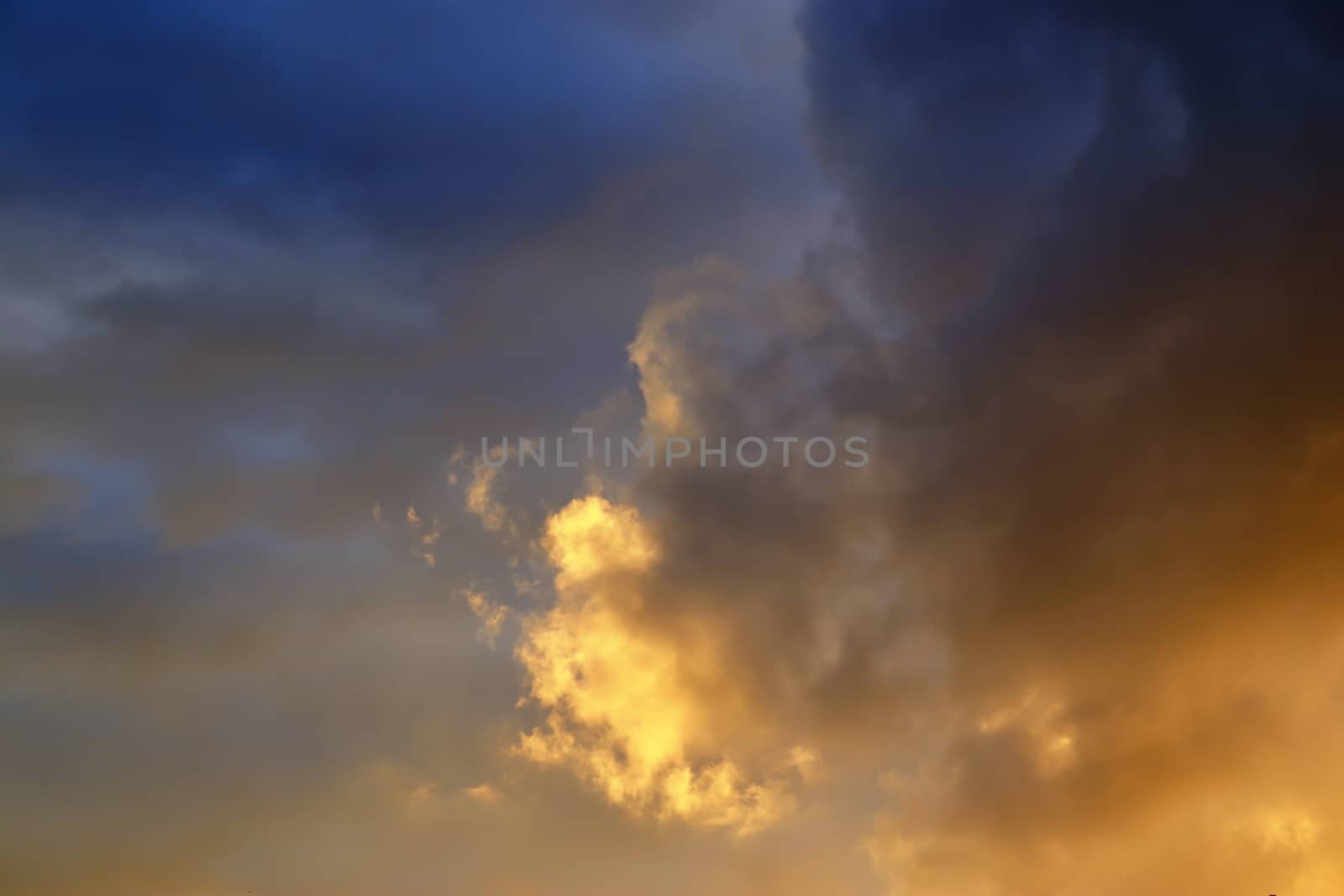 Beautiful panorama of orange and yellow clouds at sunrise and sunset in a blue sky