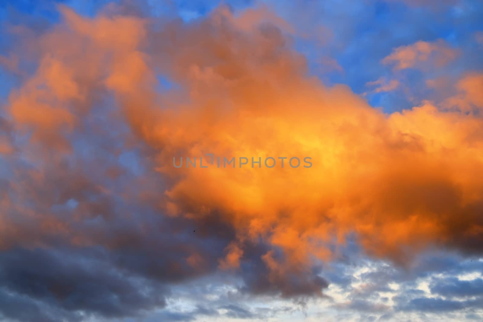 Beautiful panorama of orange and yellow clouds at sunrise and sunset in a blue sky