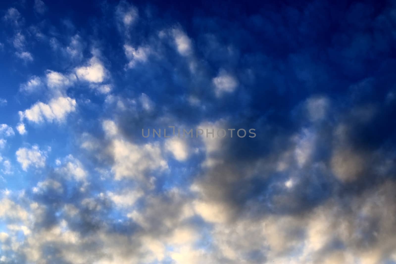 Beautiful panorama of orange and yellow clouds at sunrise and sunset in a blue sky