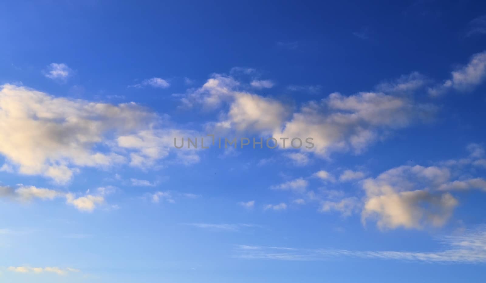 Beautiful panorama of orange and yellow clouds at sunrise and sunset in a blue sky