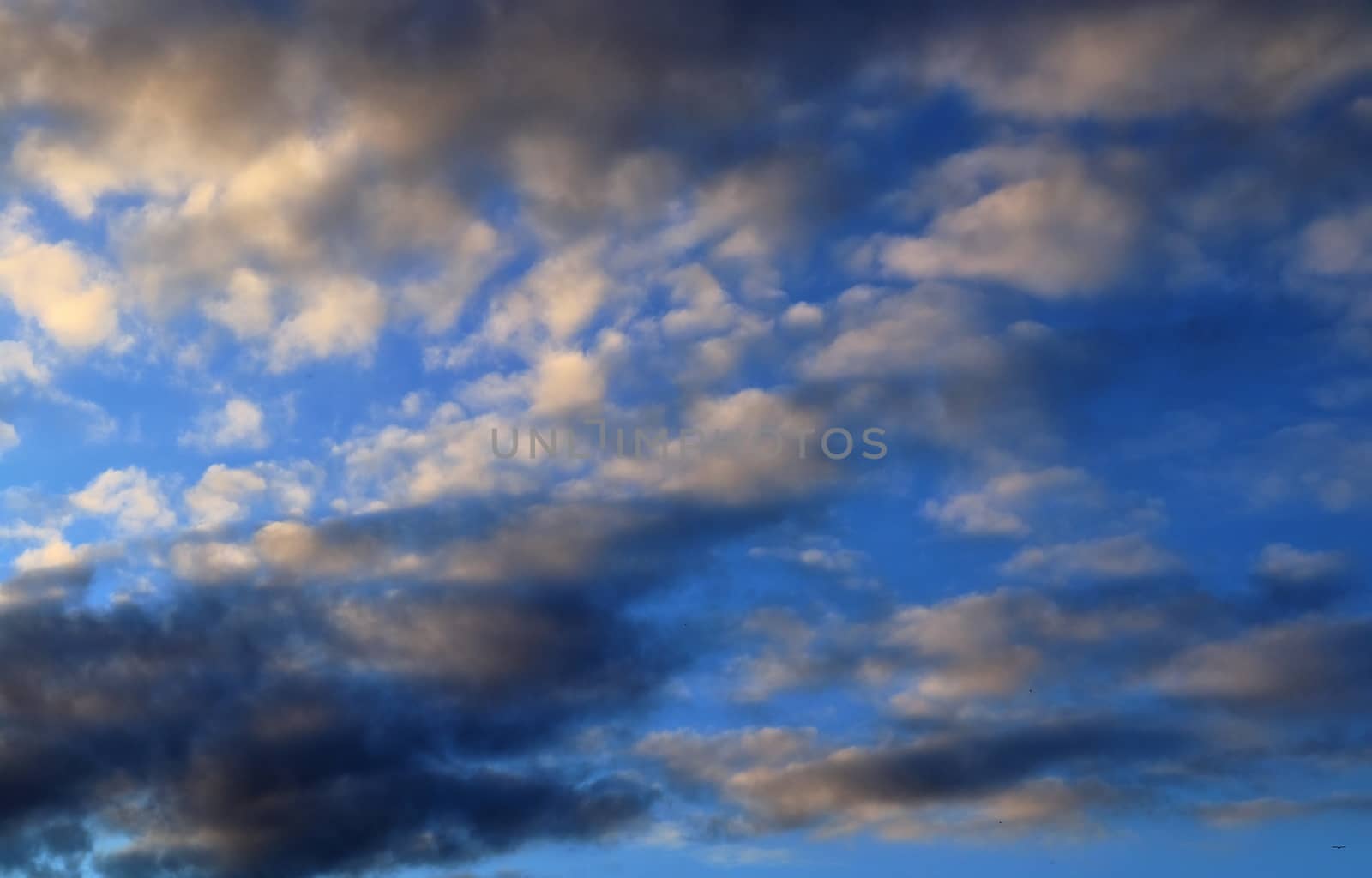 Beautiful panorama of orange and yellow clouds at sunrise and sunset in a blue sky