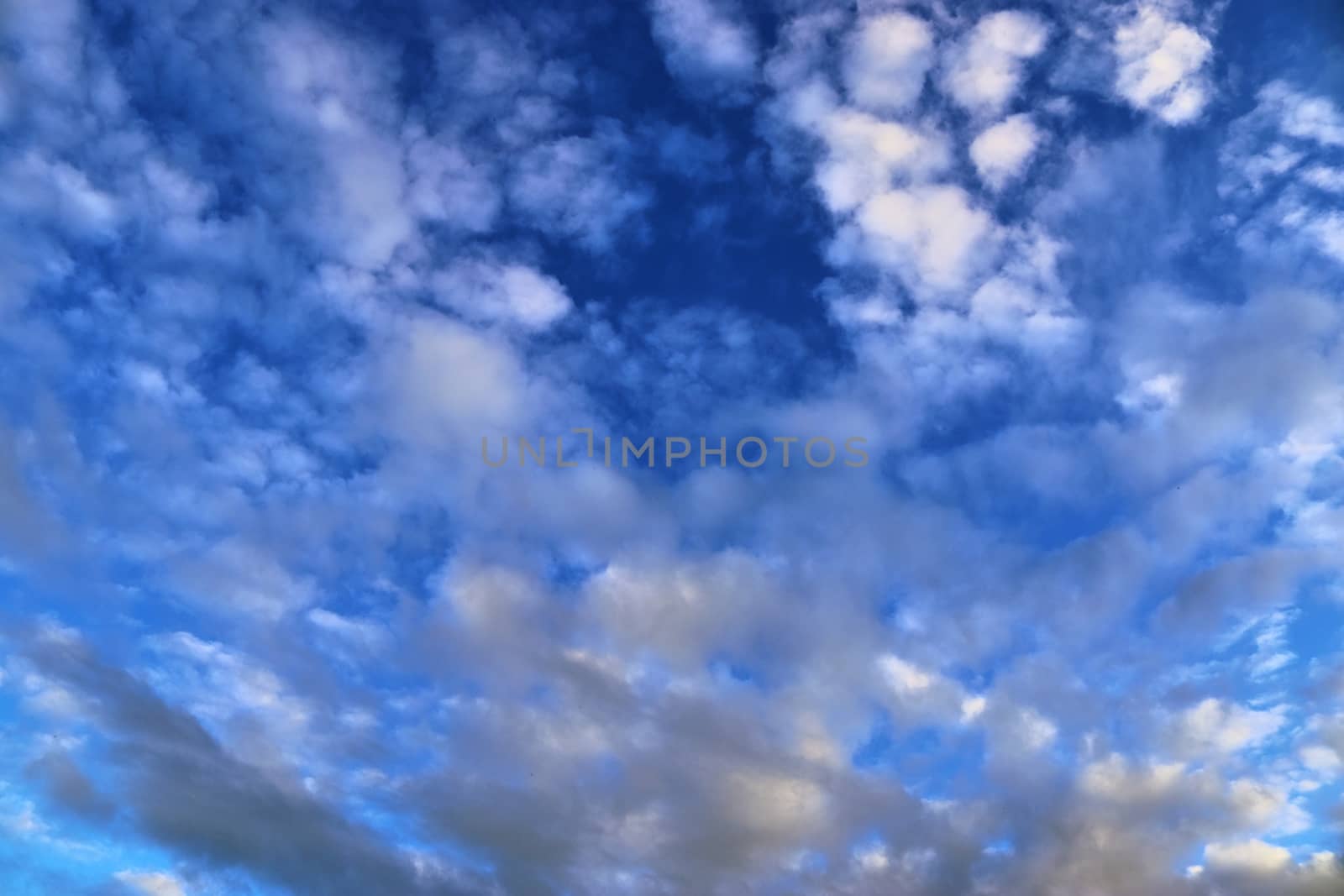 Beautiful panorama of orange and yellow clouds at sunrise and sunset in a blue sky