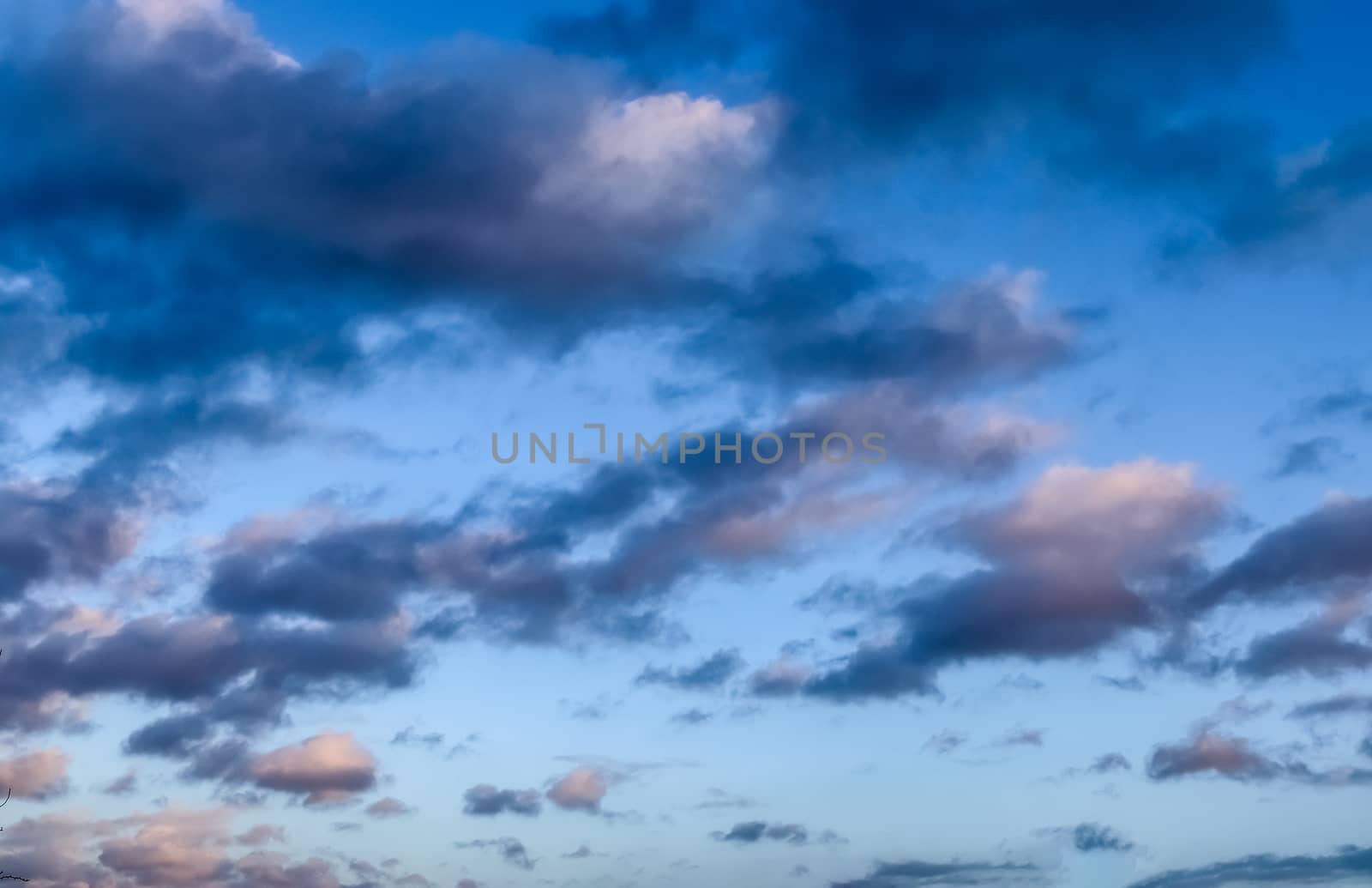 Beautiful panorama of orange and yellow clouds at sunrise and sunset in a blue sky