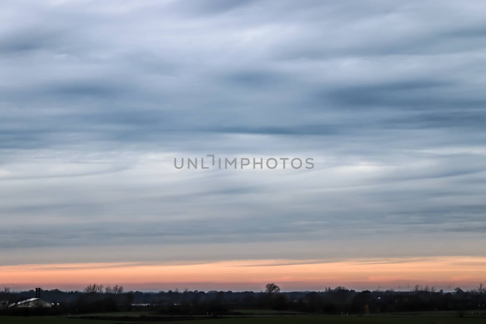 Beautiful panorama of orange and yellow clouds at sunrise and sunset in a blue sky