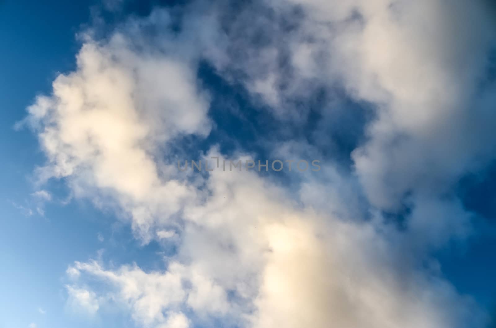 Beautiful panorama of orange and yellow clouds at sunrise and sunset in a blue sky