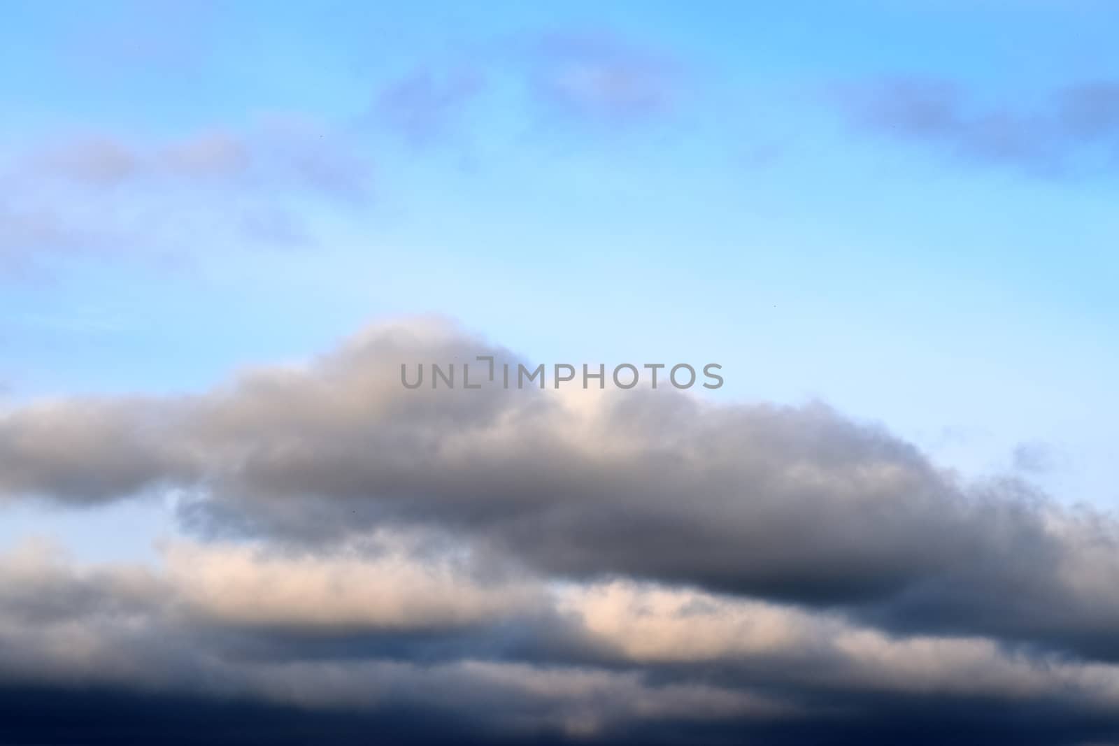 Beautiful panorama of orange and yellow clouds at sunrise and sunset in a blue sky