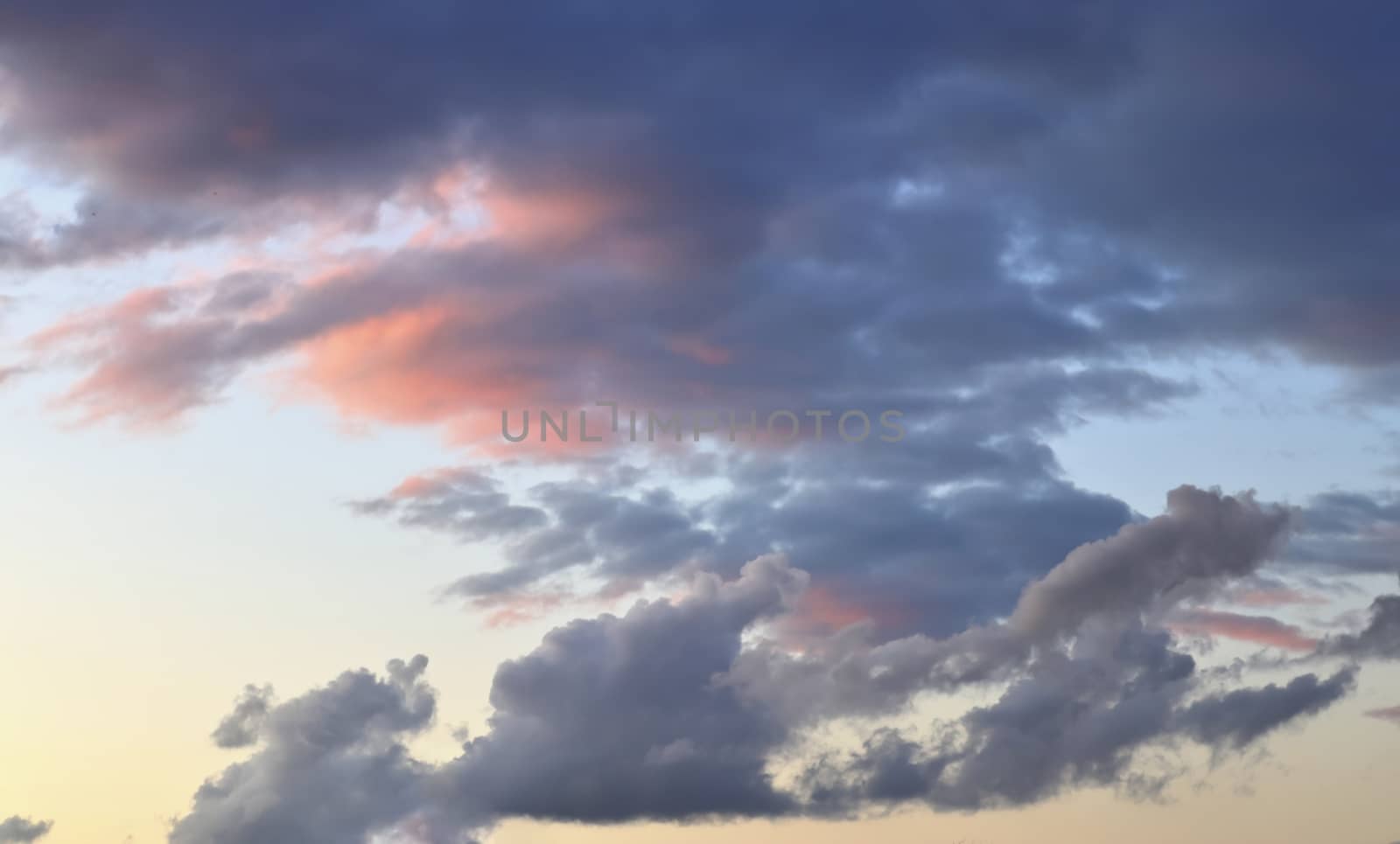 Beautiful panorama of orange and yellow clouds at sunrise and sunset in a blue sky