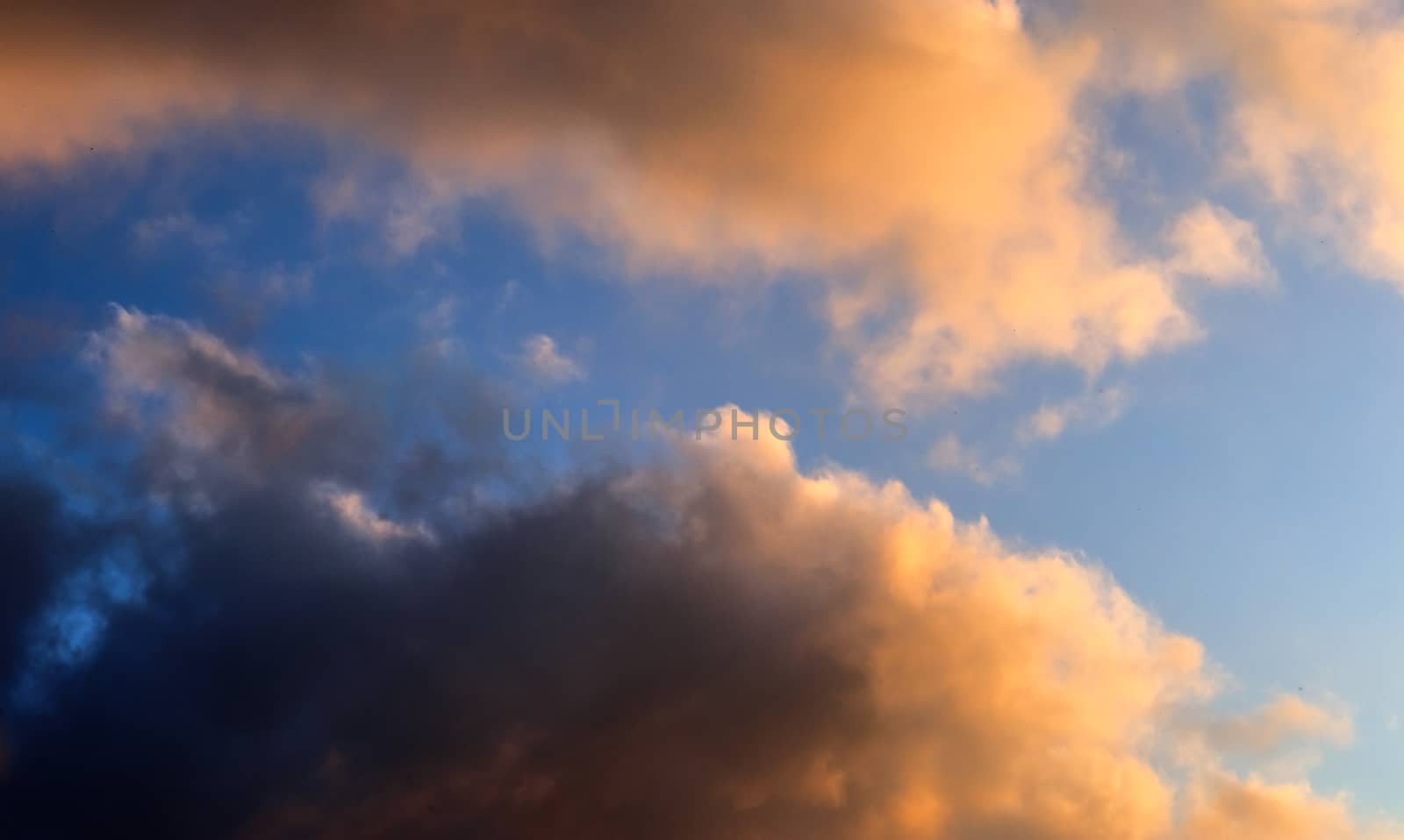 Beautiful panorama of orange and yellow clouds at sunrise and sunset in a blue sky