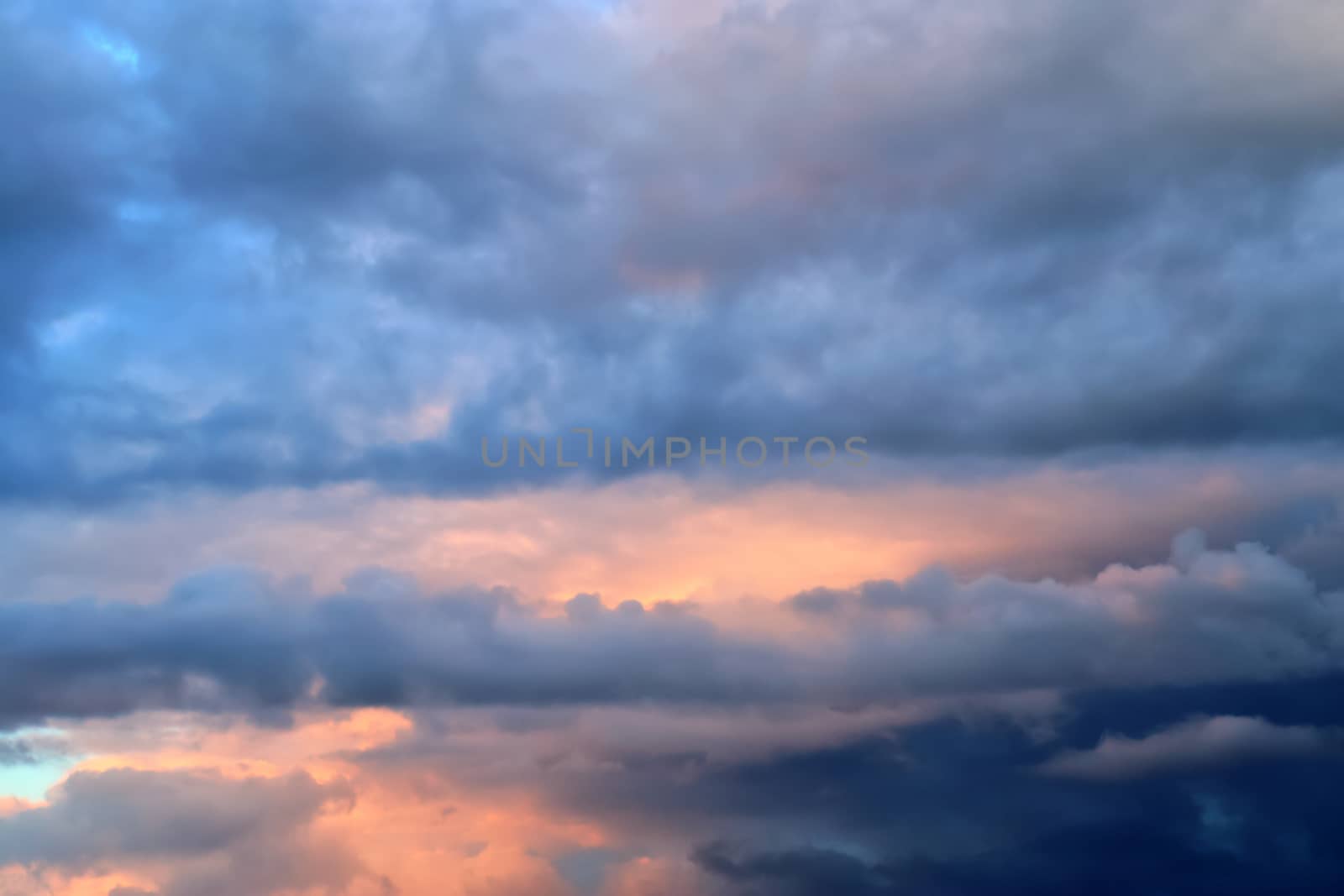 Beautiful panorama of orange and yellow clouds at sunrise and sunset in a blue sky