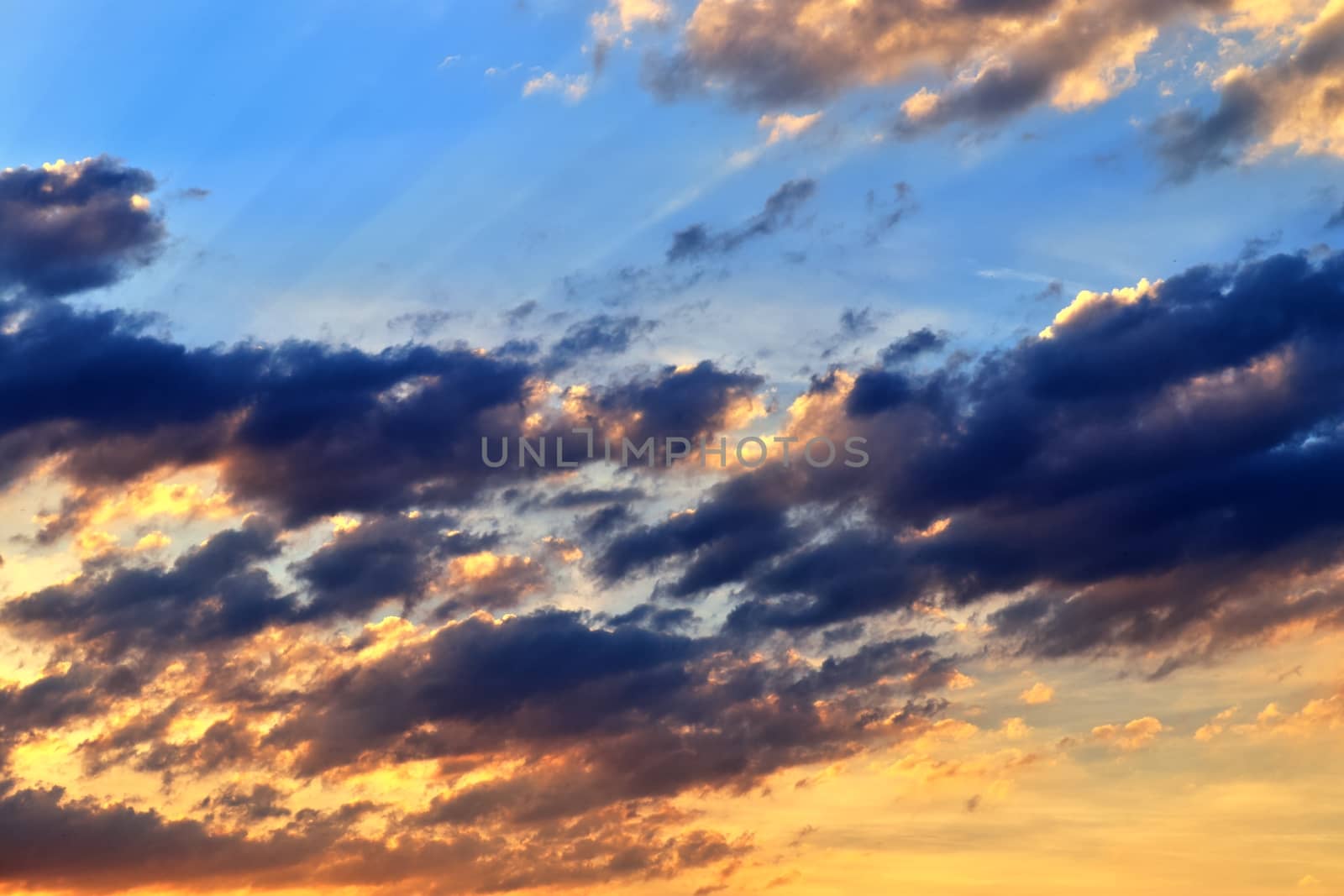 Beautiful panorama of orange and yellow clouds at sunrise and sunset in a blue sky