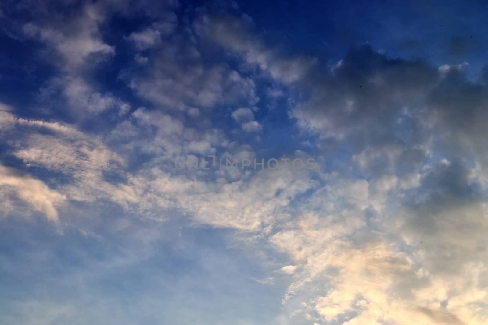 Beautiful panorama of orange and yellow clouds at sunrise and sunset in a blue sky