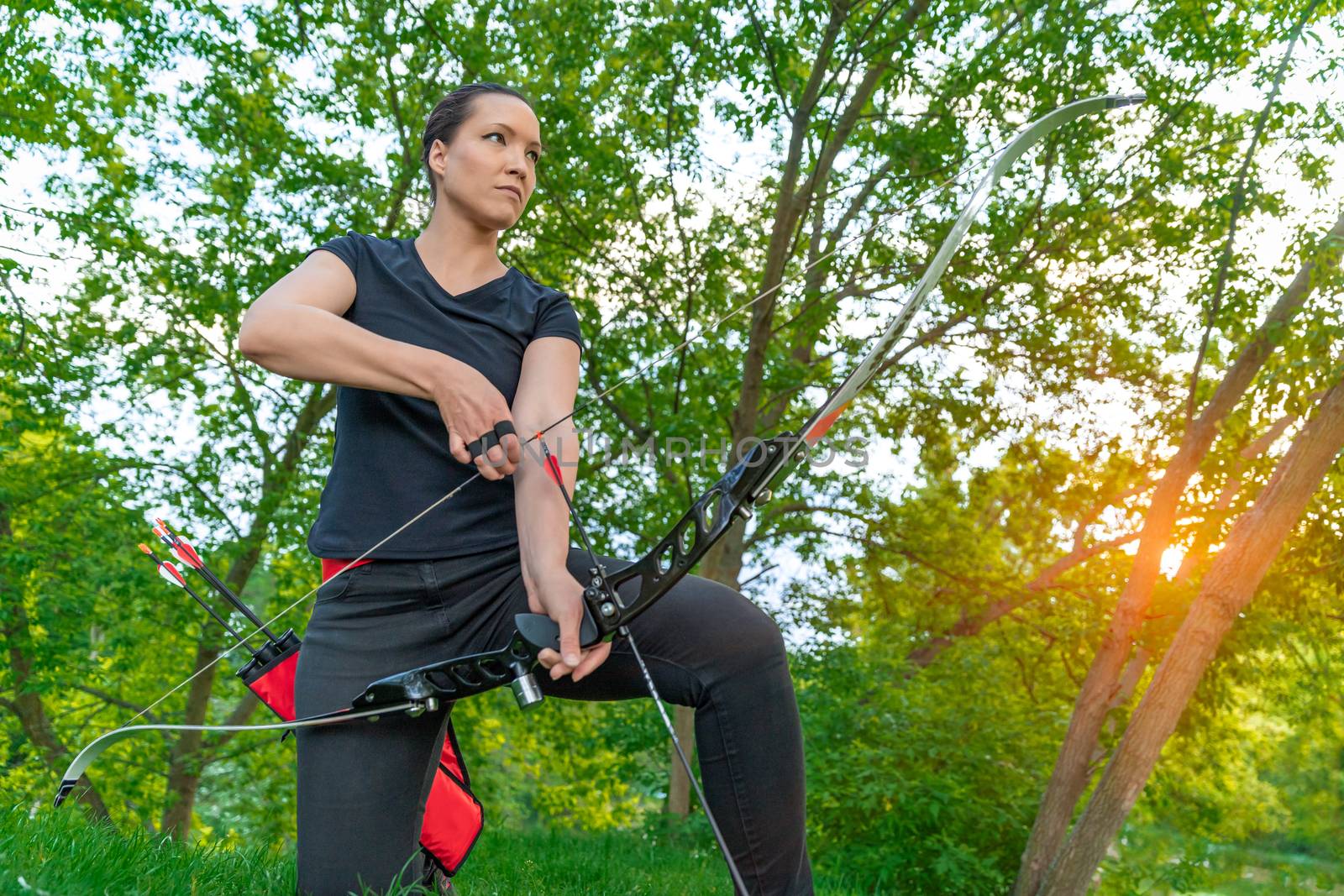 arrow shooting from a bow in nature, sport archery. copy space by Edophoto