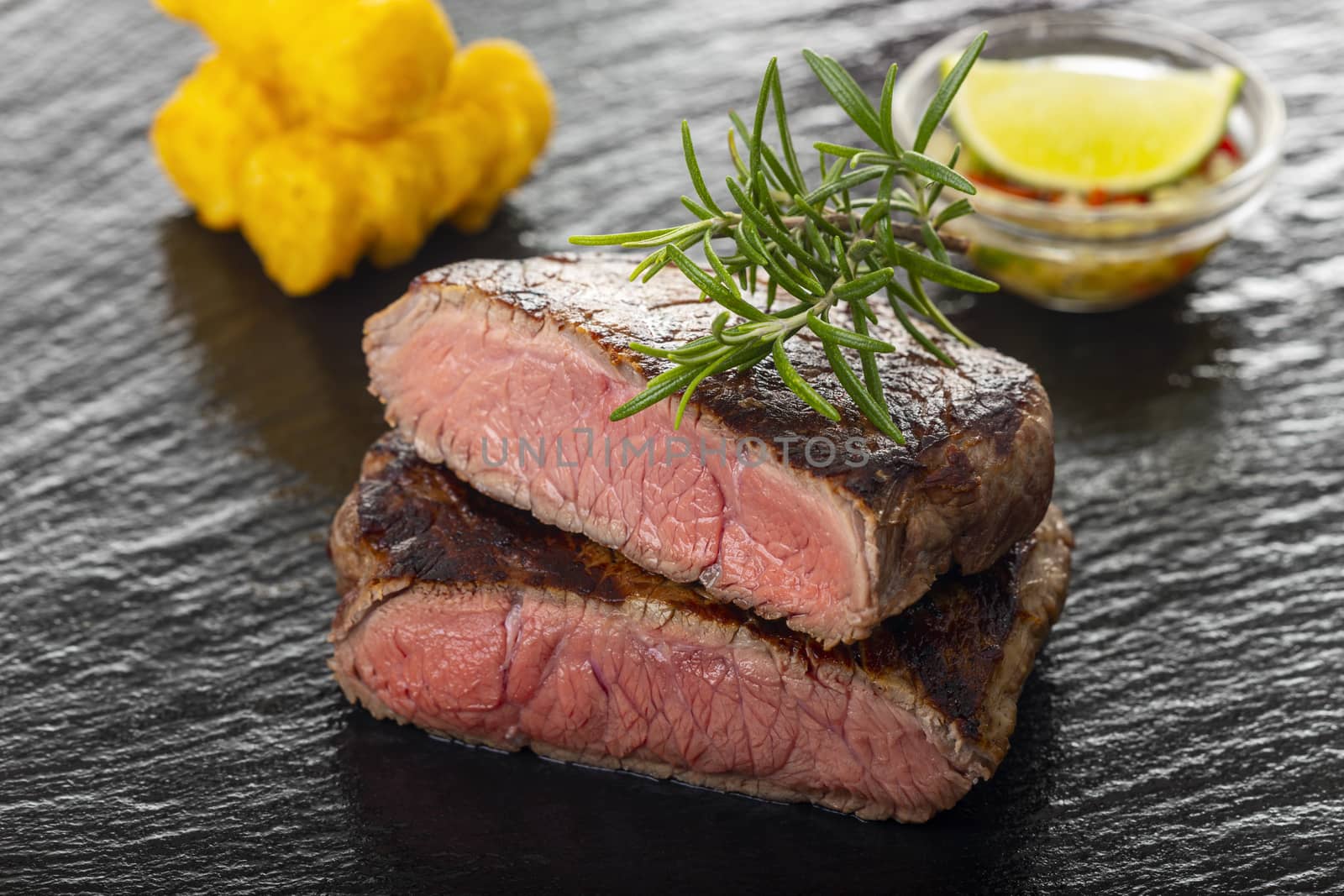 slices of grilled steak on black slate