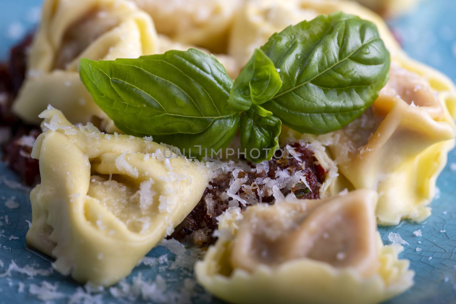 tortellini with olive oil on a blue plate