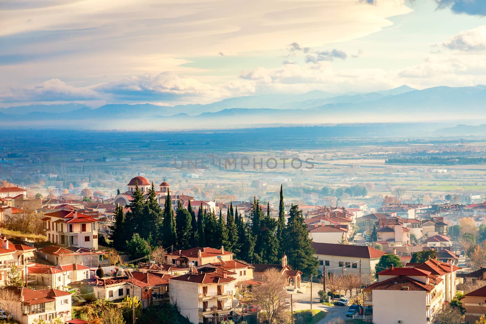 Greek town evening panorama with red roof houses, valley and mountains in the background, Kalambaka, Thessaly, Greece