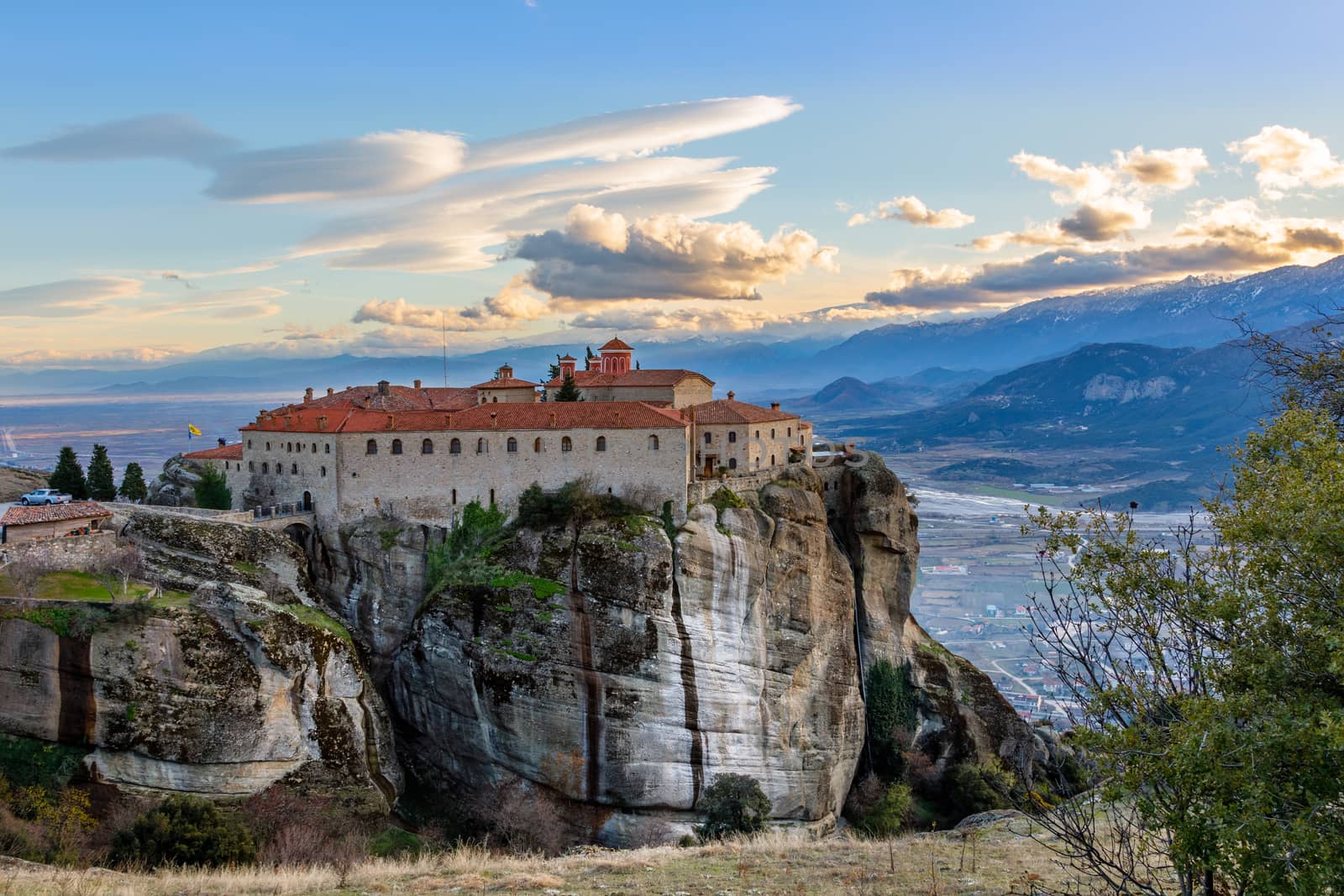 Agios Stephanos or Saint Stephen monastery located on the huge rock with mountains and town landscape in the background, Meteors, Trikala, Thessaly, Greece