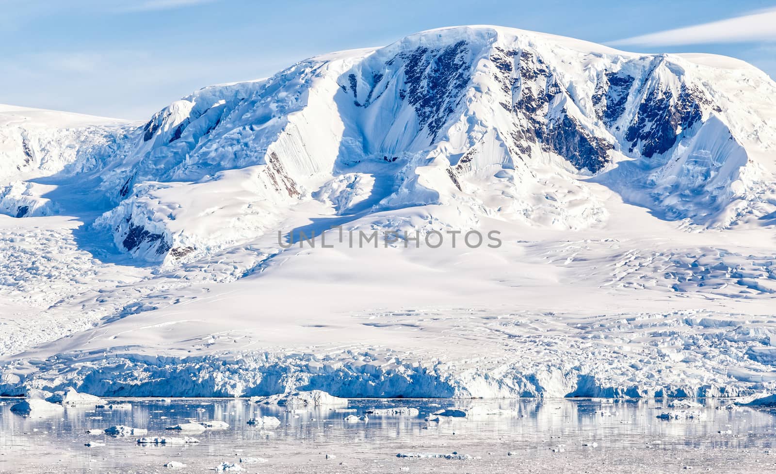 Antarctic mountain covered with snow glacier and waters with icebergs, Neco bay, Antarctica