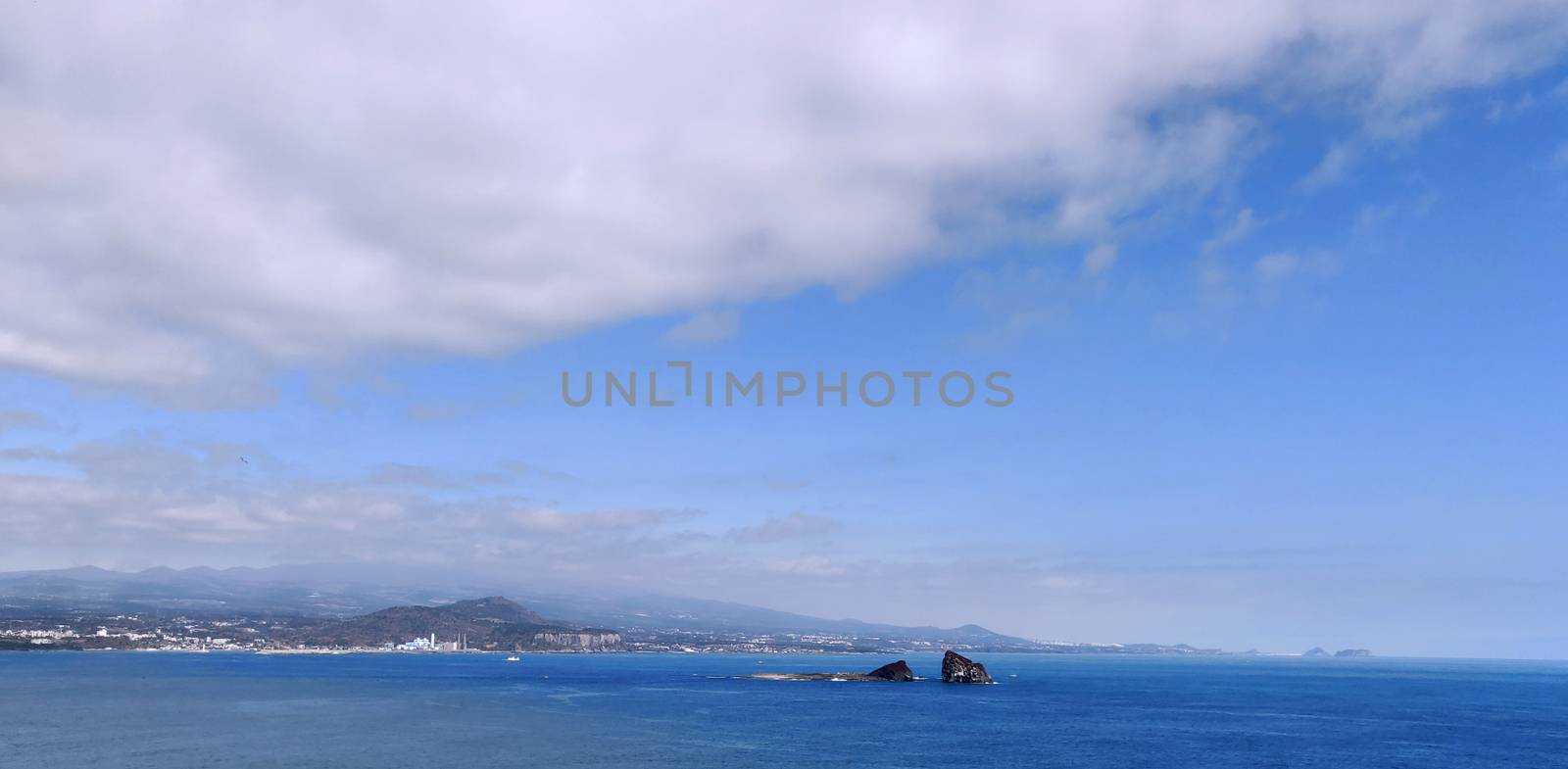 Bright blue never-ending sea with white clouds in the blue sky in Jeju Island, South Korea