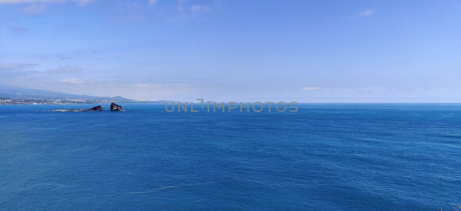 Wide angle shot of the brightest blue empty ocean and sky in Jeju Island, South Korea