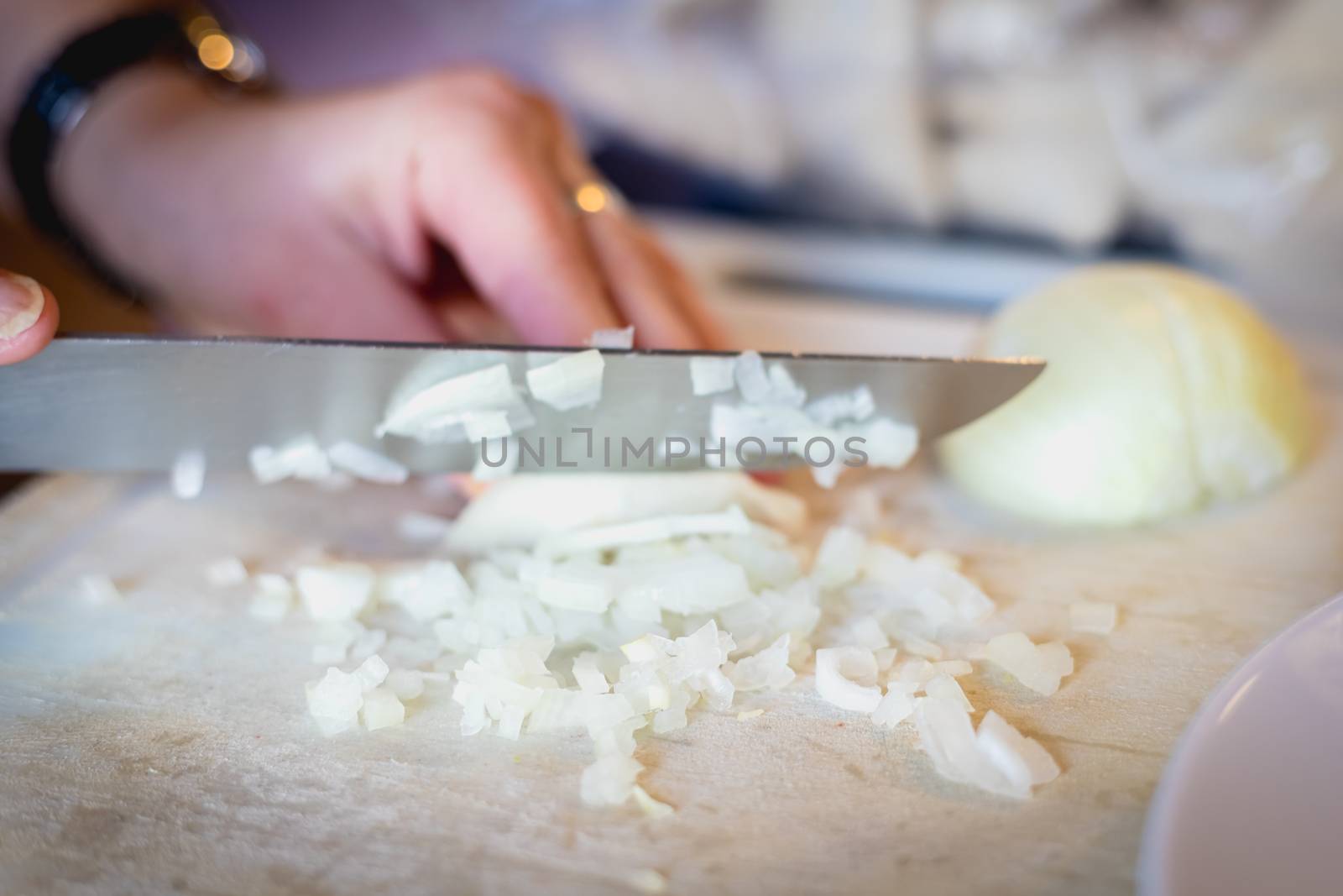 woman cuts onions on a white plastic board  by AtlanticEUROSTOXX