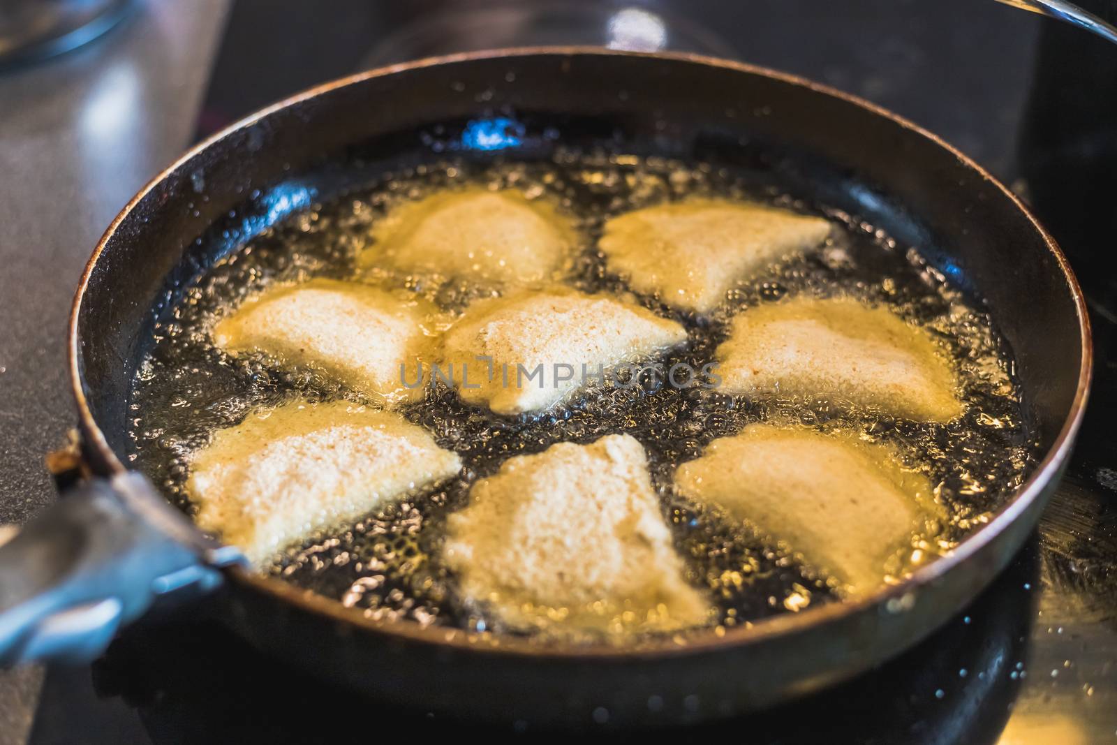 fried portuguese or brazilian rissoles in a pan in a kitchen