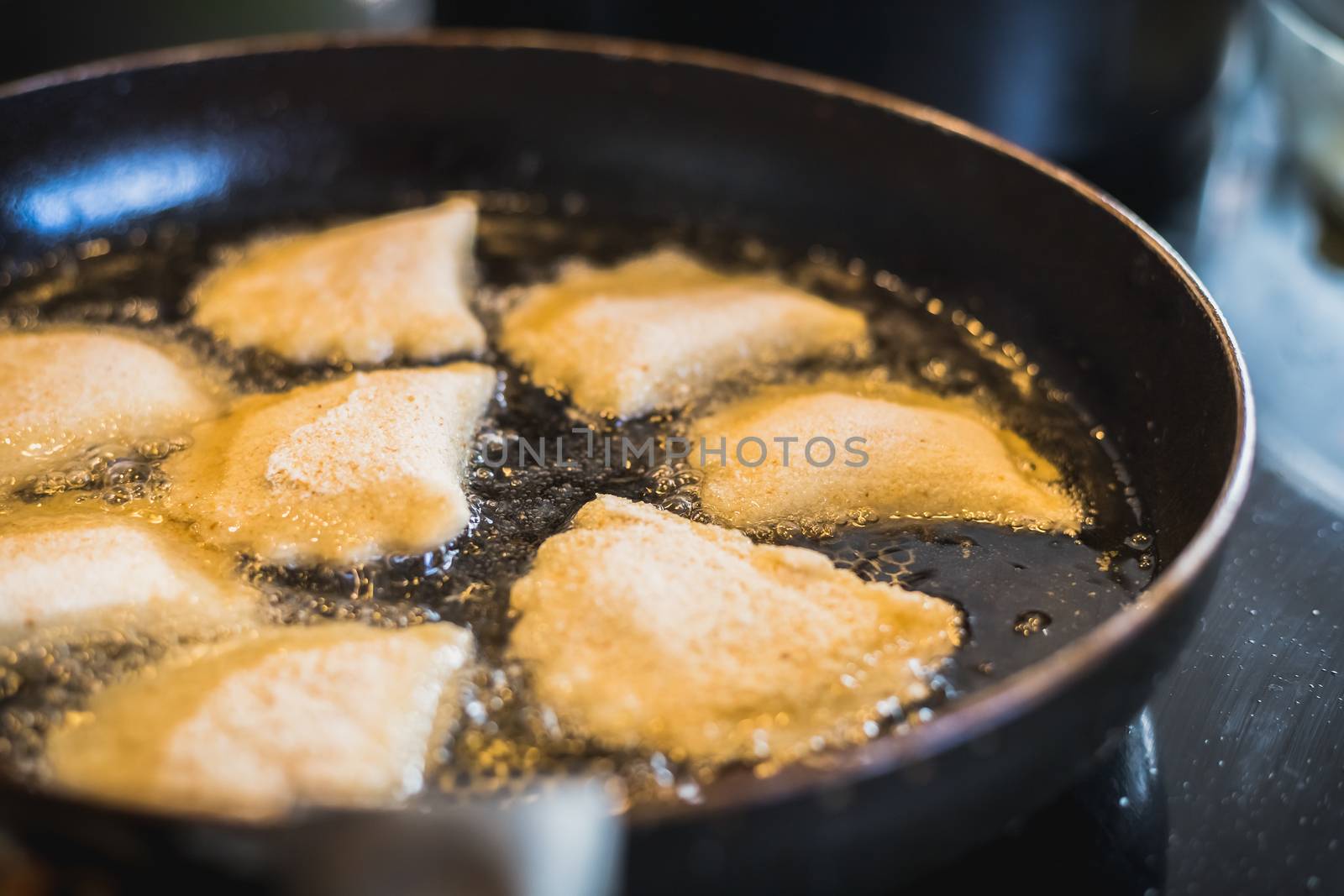 fried portuguese or brazilian rissoles in a pan in a kitchen