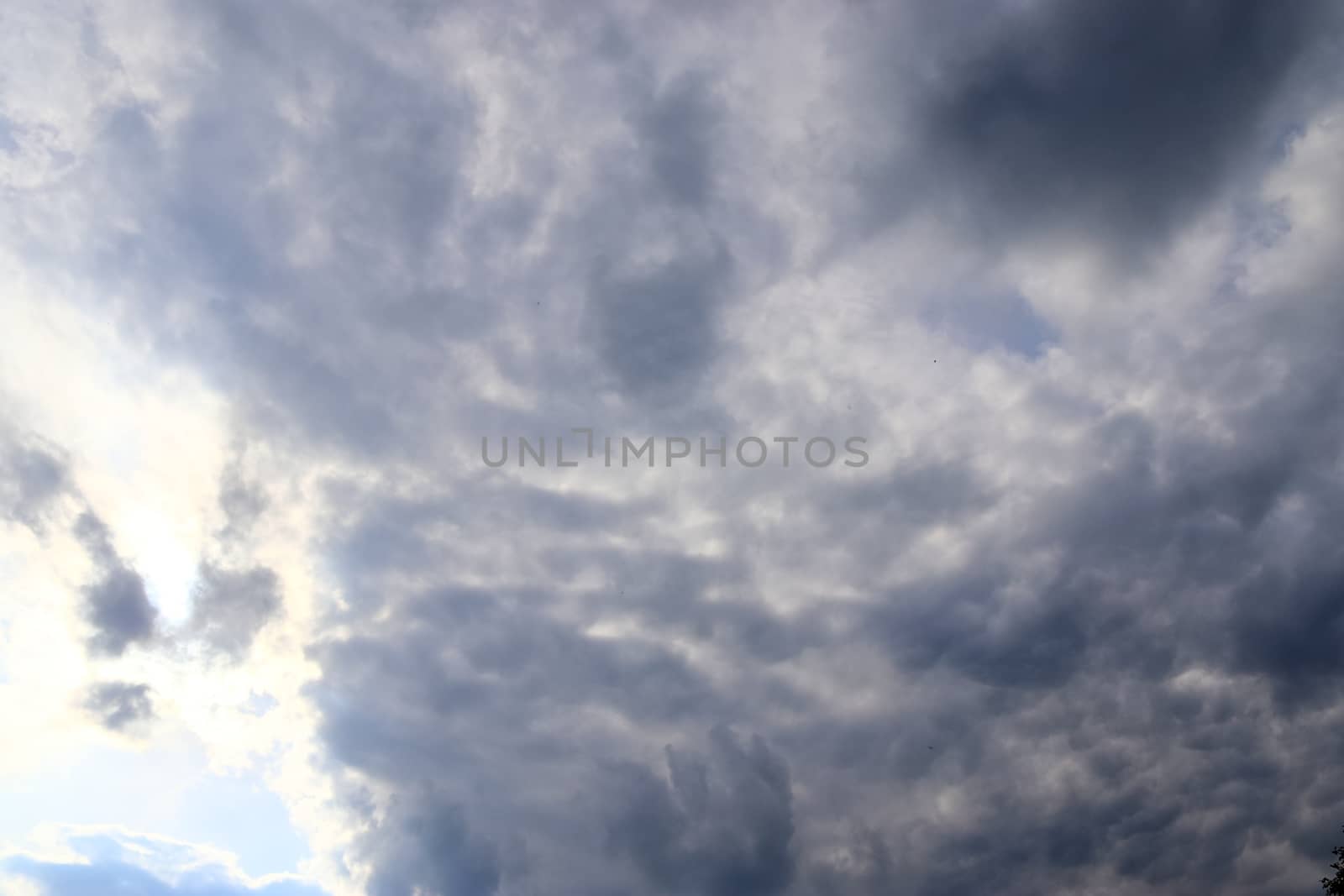 Beautiful view at bright sunbeams with some lens flares and clouds in a blue sky