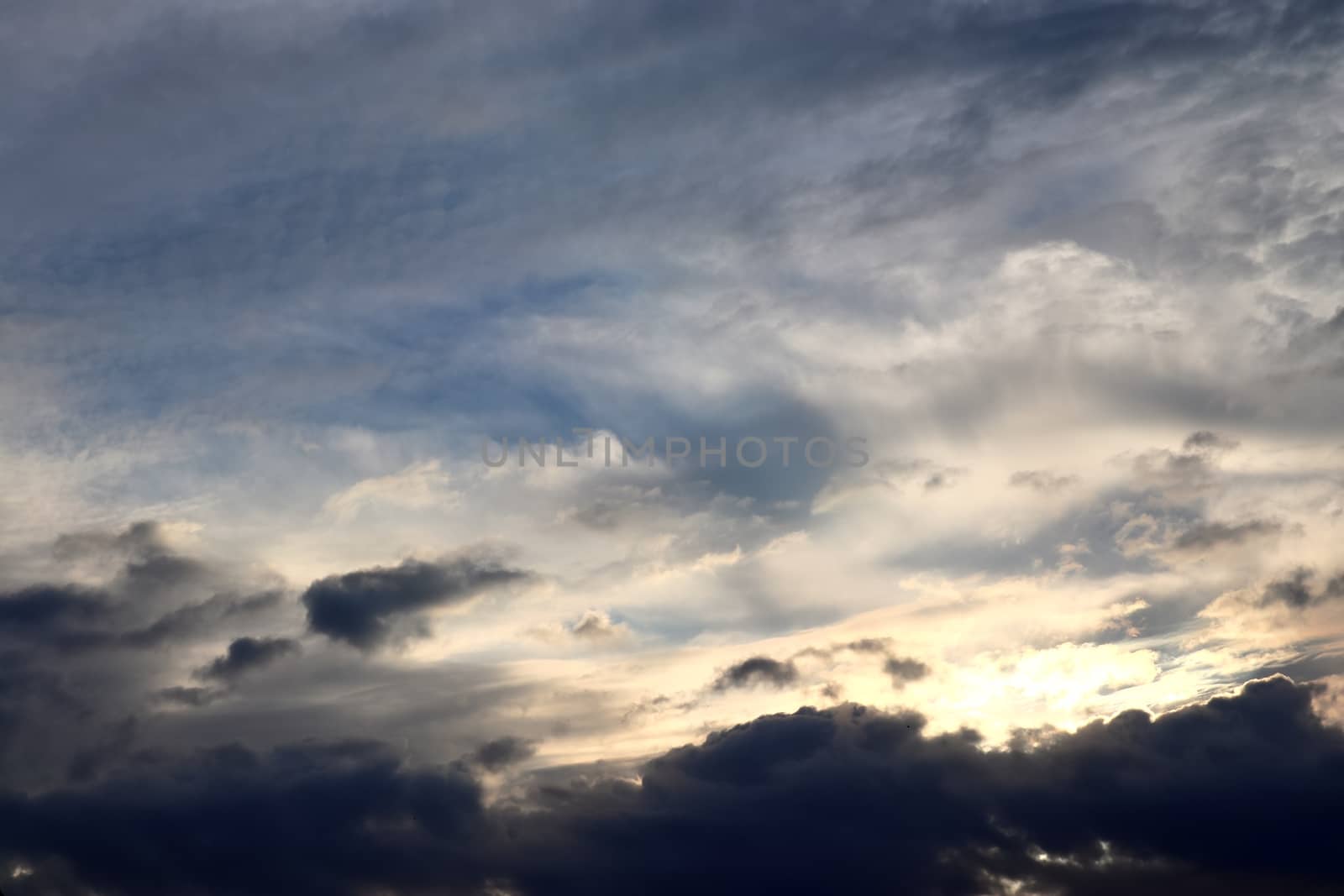 Beautiful view at bright sunbeams with some lens flares and clouds in a blue sky