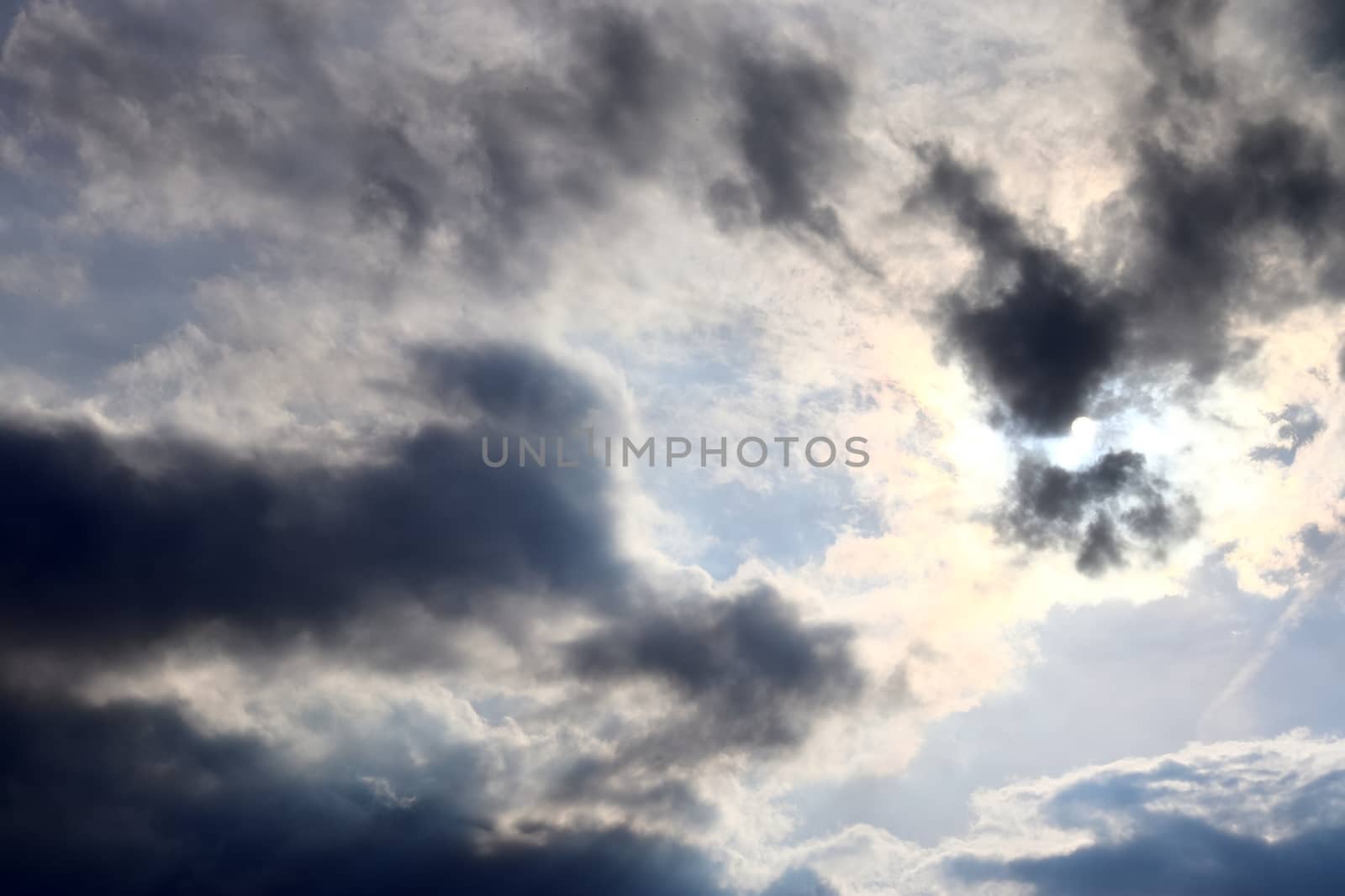 Beautiful view at bright sunbeams with some lens flares and clouds in a blue sky