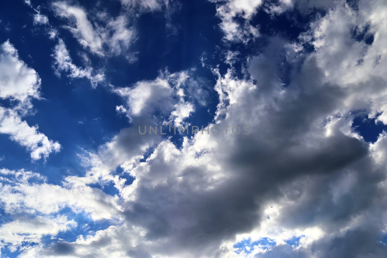 Beautiful view at bright sunbeams with some lens flares and clouds in a blue sky