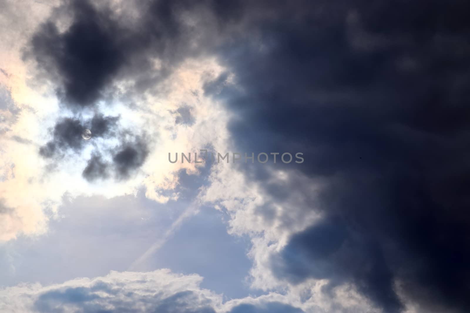 Beautiful view at bright sunbeams with some lens flares and clouds in a blue sky