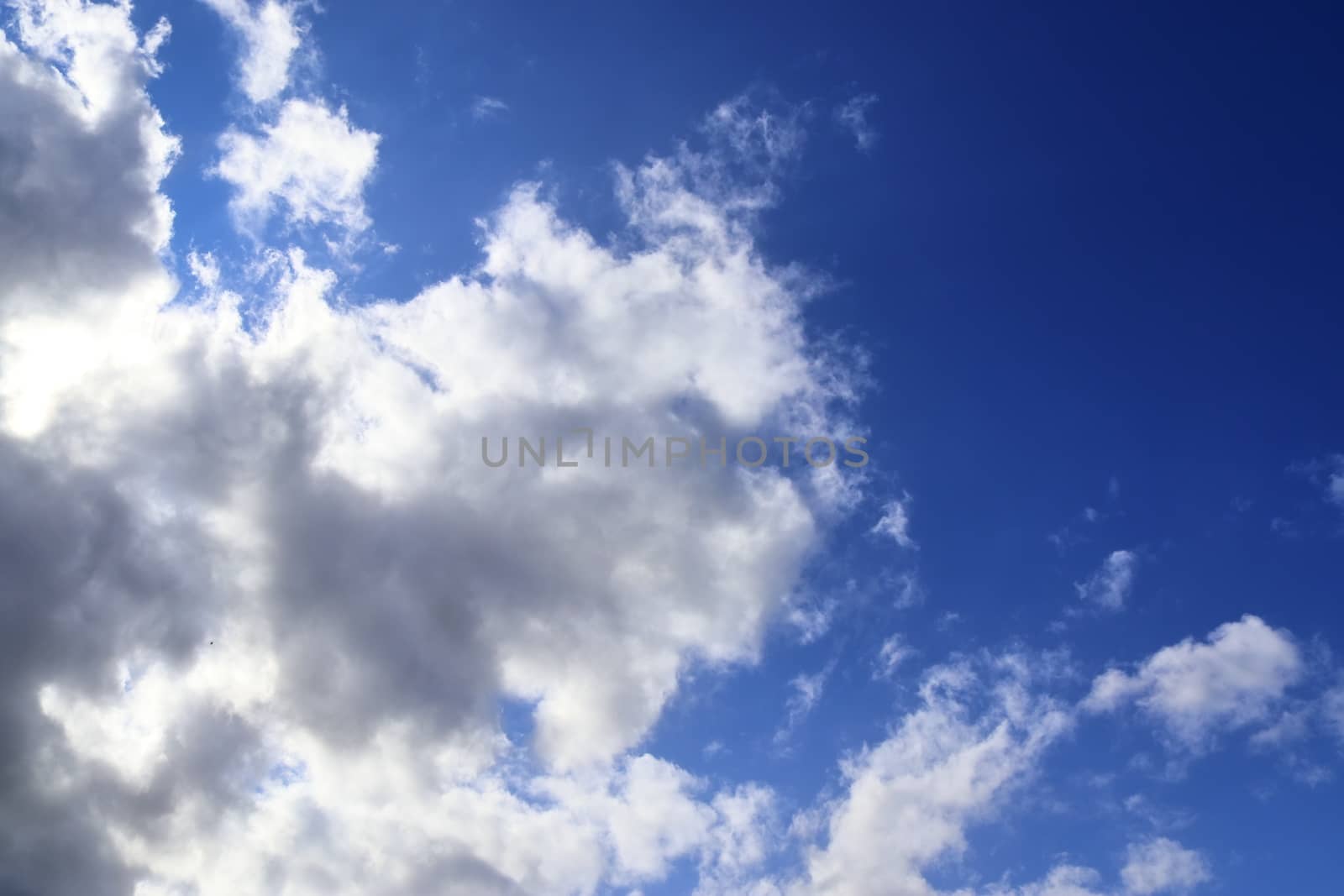 Beautiful view at bright sunbeams with some lens flares and clouds in a blue sky