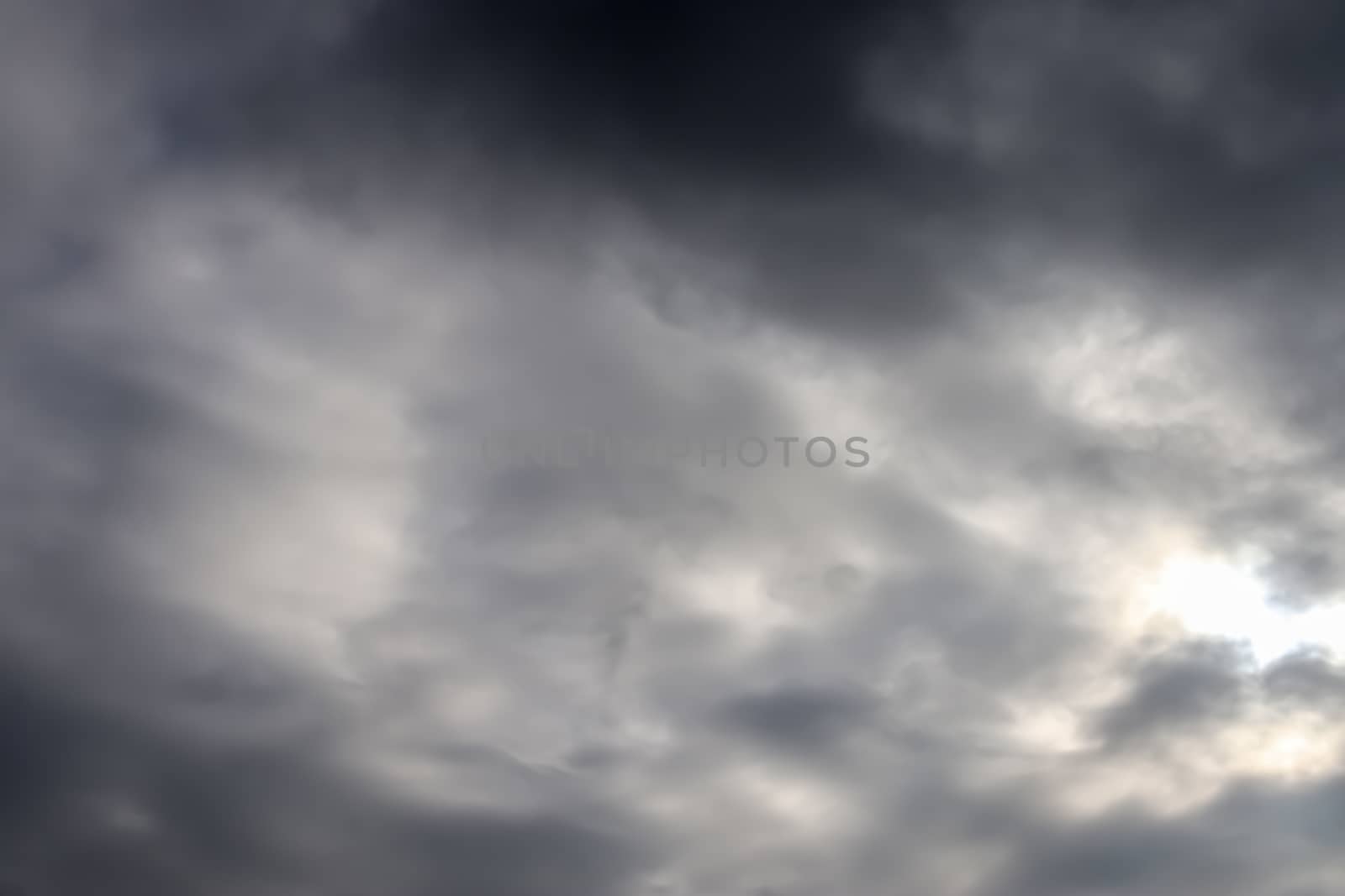 Beautiful view at bright sunbeams with some lens flares and clouds in a blue sky