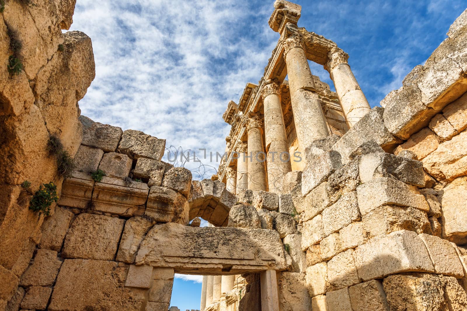 Columns of ancient Roman temple of Bacchus with surrounding ruins and blue sky in the background, Beqaa Valley, Baalbeck, Lebanon